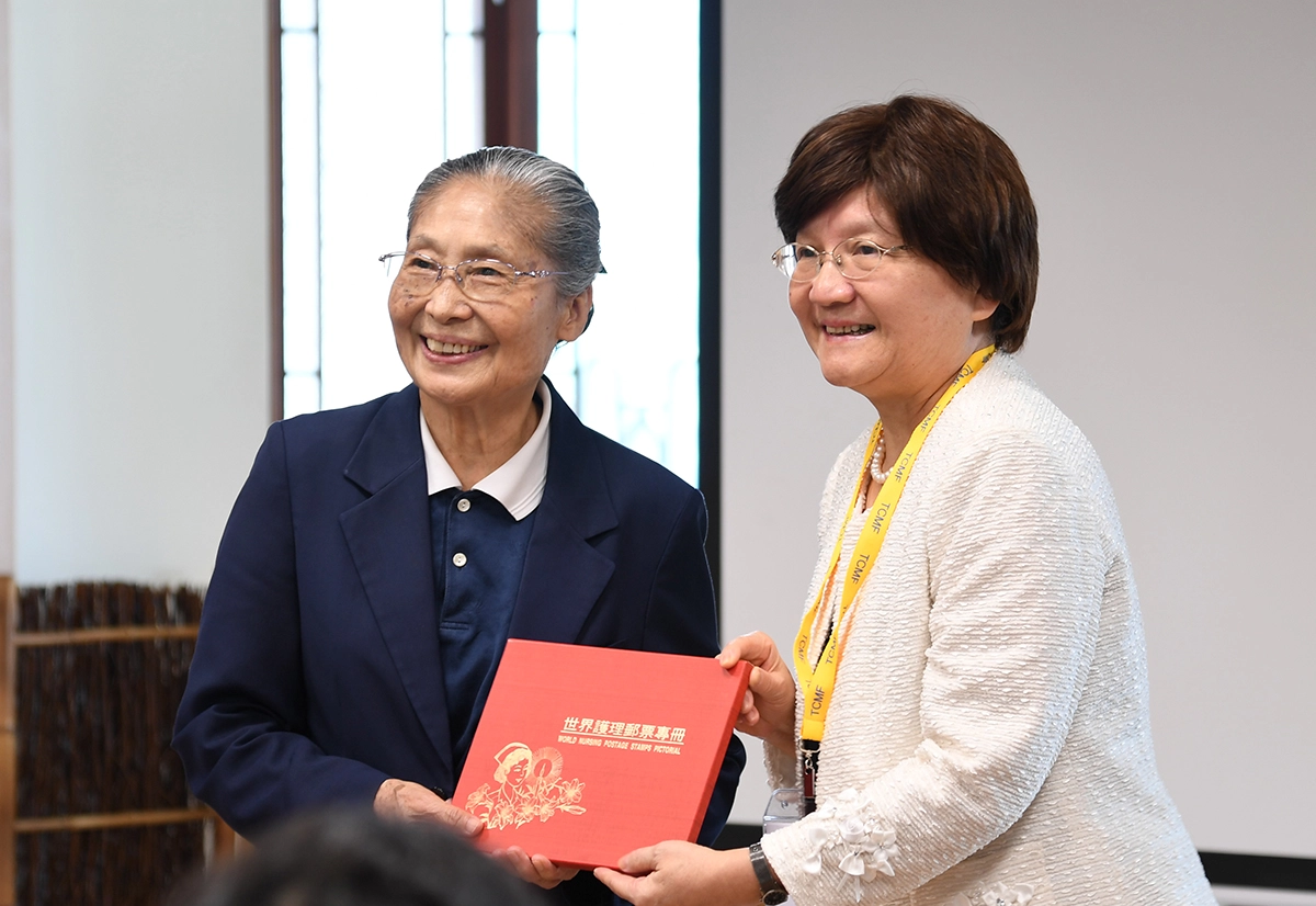 考試委員李選(右)贈與林碧玉副總執行長(左)郵票專冊。