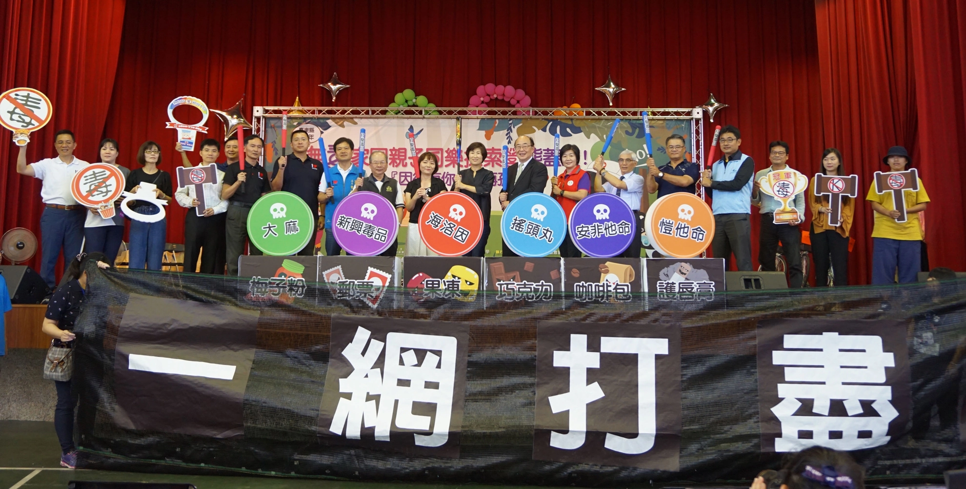 縣長和與會來賓共同宣誓「打擊毒品,一網打盡」!長官們透過手上棒子,將舞台區各類毒品牆推倒至舞台下網子裡!象徵「打擊毒品」,將毒品「一網打盡」的決心。(圖/慈濟基金會)