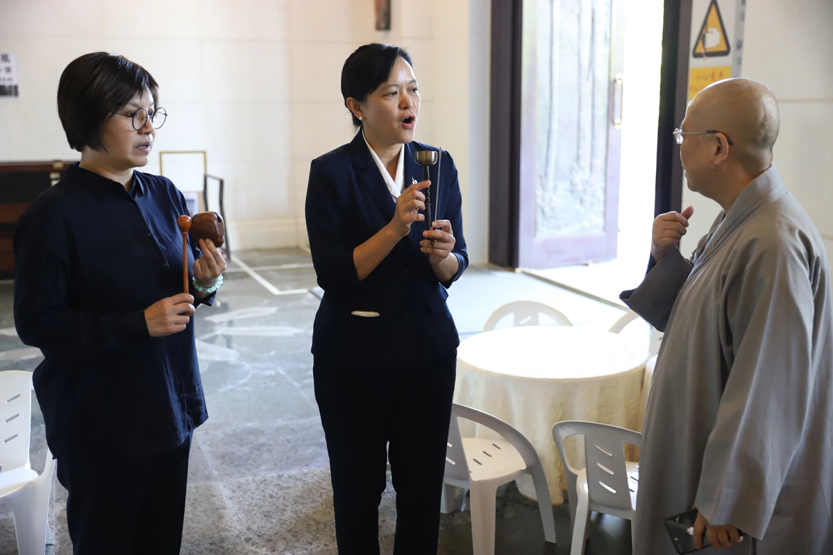 文化獎得主唐美雲與慈濟大學劉怡均校長把握相見的時間練習,靜思精舍法師德宣師父在旁給予意見和協助。(圖/慈濟基金會提供)