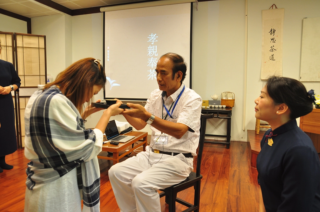 學員們學習奉茶禮儀的「三心」:感恩心(端捧茶盤)、尊重心(敬上茶盞)與愛心(微笑颌首)。