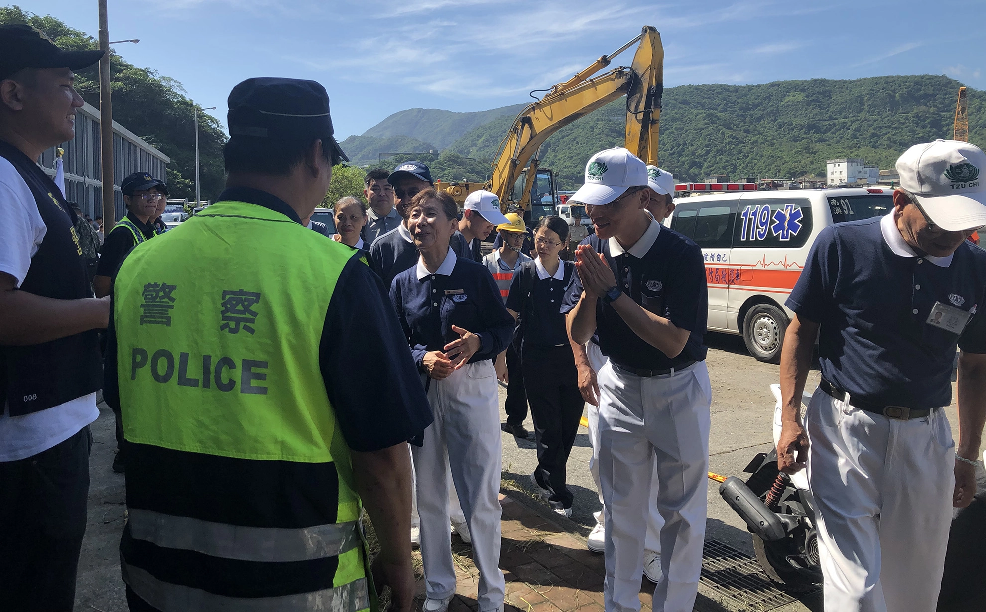 慈濟慈善志業執行長顏博文(左)於10月2日一早前往南方澳現場,向救災人員致意。