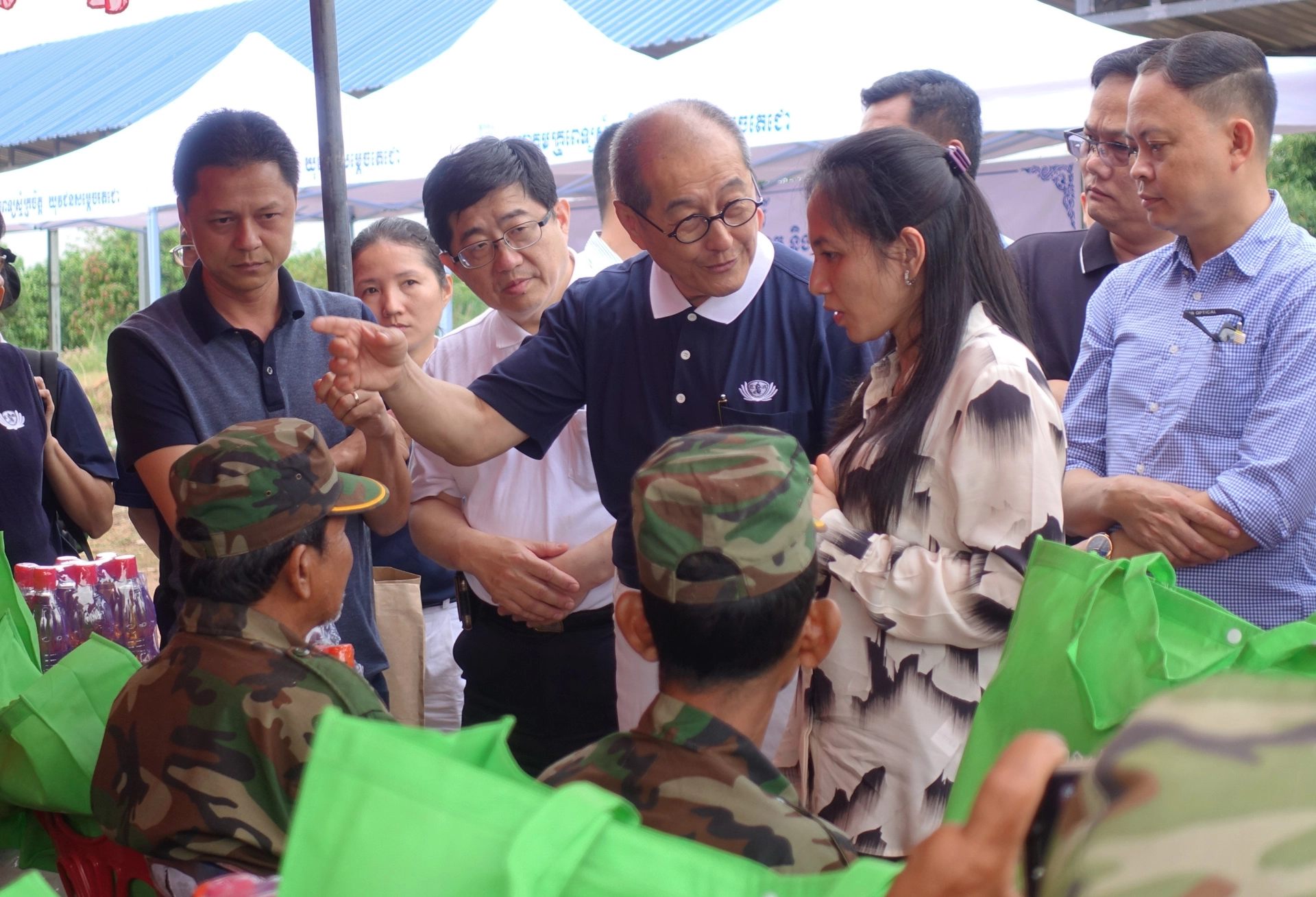 當地村民高文淵(坐者,左一)向貝占莫妮洪馬內夫人(站者,右二)表示身上還有砲彈,慈濟基金會劉濟雨副執行長(站者,左三)、大林慈濟醫院林名男副院長(站者,左二)建議隔天到慈濟義診的地方看診。(攝影:陳誼謙)
