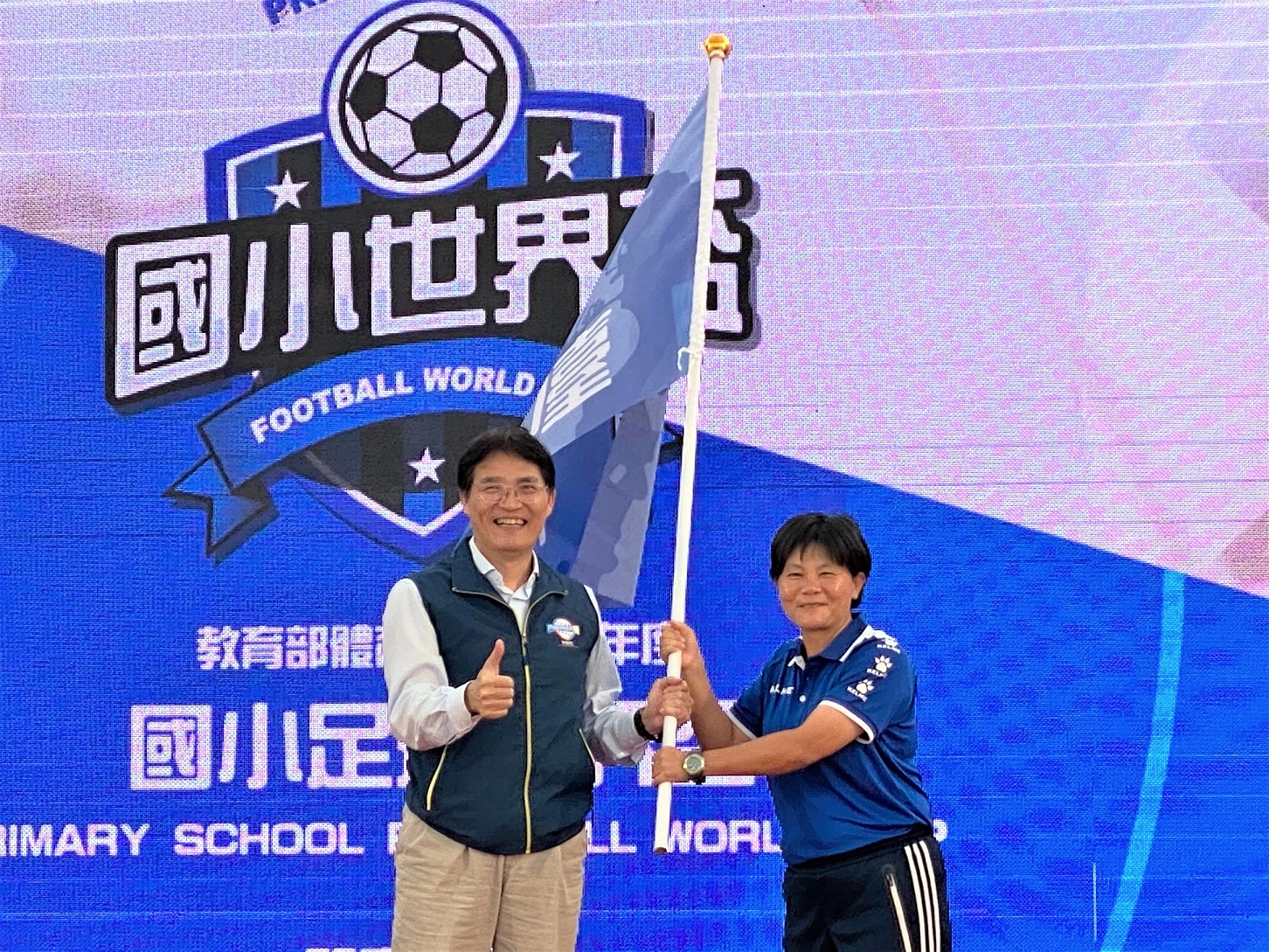 體育署高俊雄署長(左)授旗予臺中市代表國立臺灣體育運動大學呂桂花教授(右),照片教育部提供。