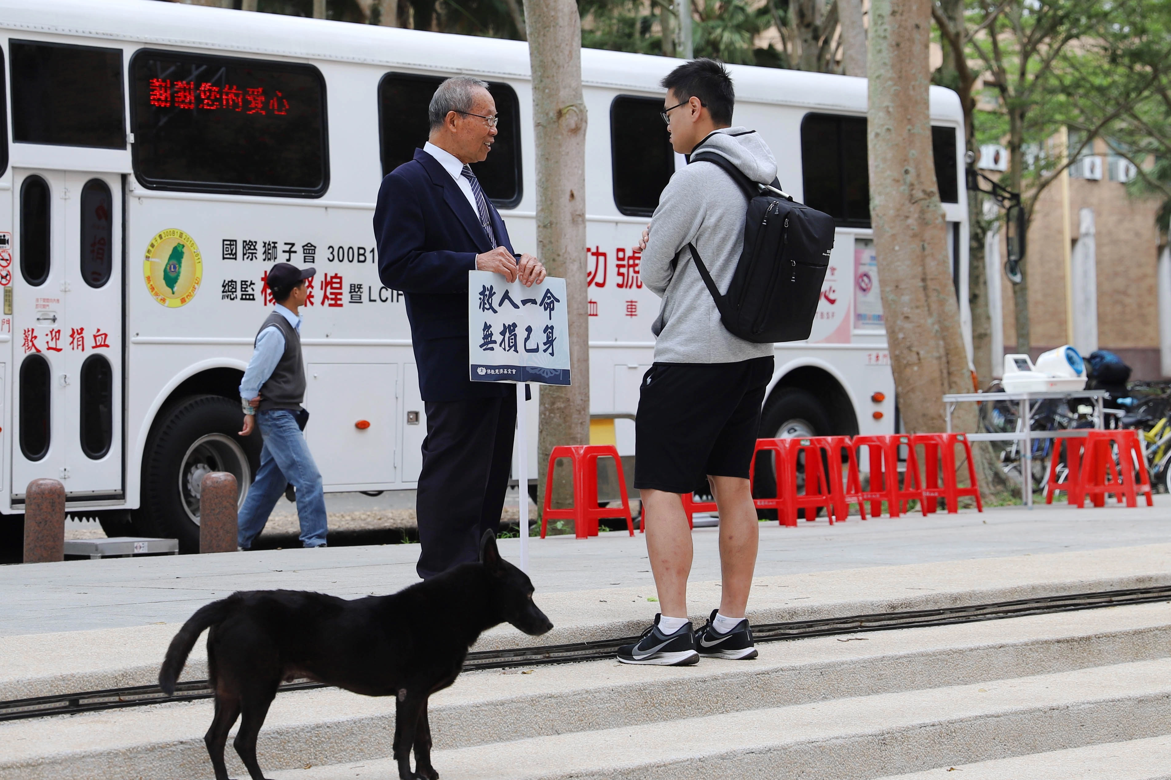 東華大學與慈濟骨髓幹細胞中心共同辦理的造血幹細胞驗血建檔活動於3日起一連三天在東華湖畔廣場辦理,志工舉牌「救人一命無損己身」,吸引不少學生前往了解。(慈濟基金會提供)