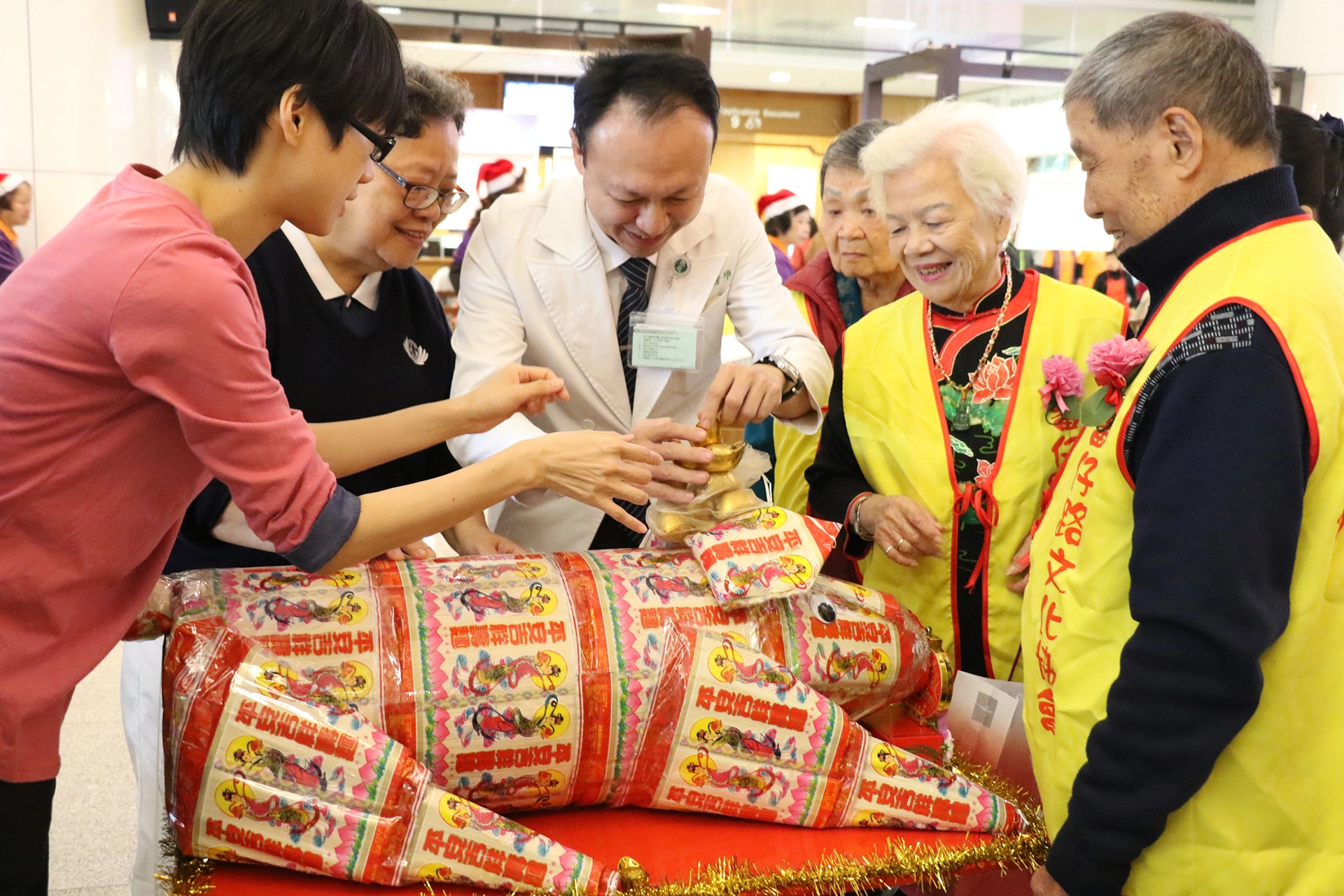 臺中慈濟醫院醫師、志工與社區長輩,在用麵線做成的豬上「堆疊幸福」,期待「諸」事順心。
