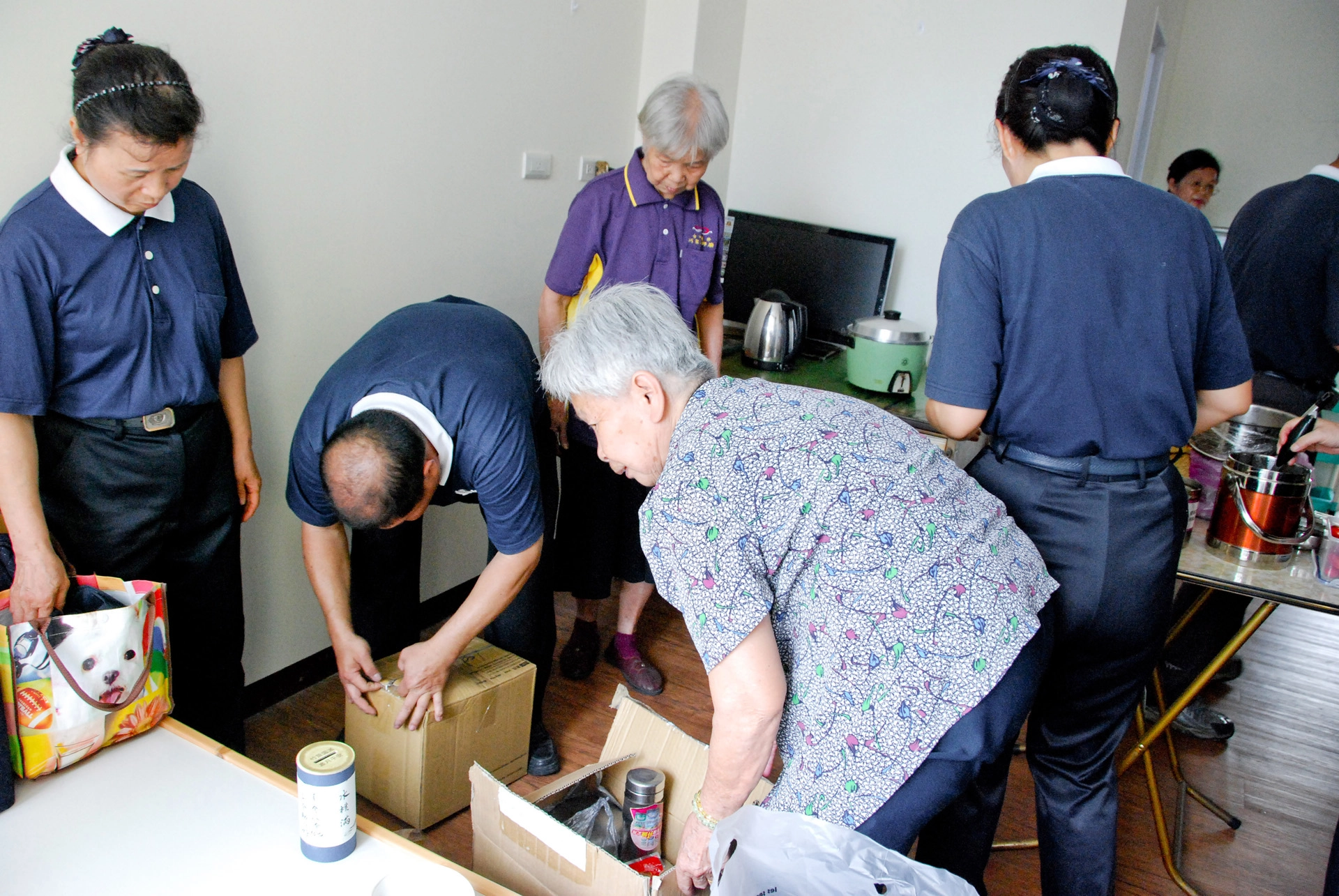 慈濟志工協助阿嬤住進安養中心,並幫忙搬運電視、冰箱、桌椅等生活用品,也布置阿嬤的新房間。
