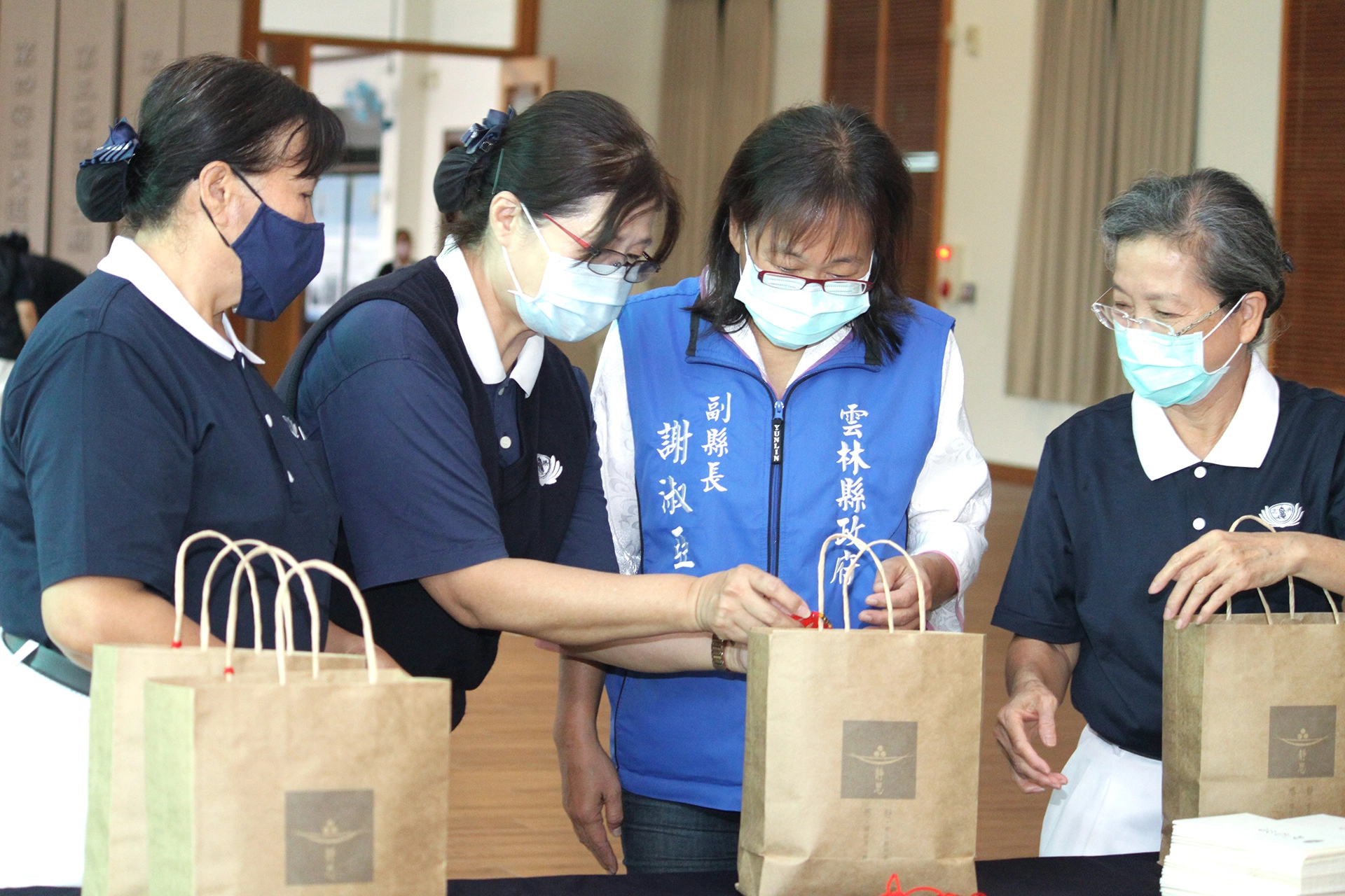 雲林縣副縣長謝淑亞(右二)代表雲林縣政府特地來慈濟雲林聯絡處關心志工的打包情況,也親自體驗打包的心情。
