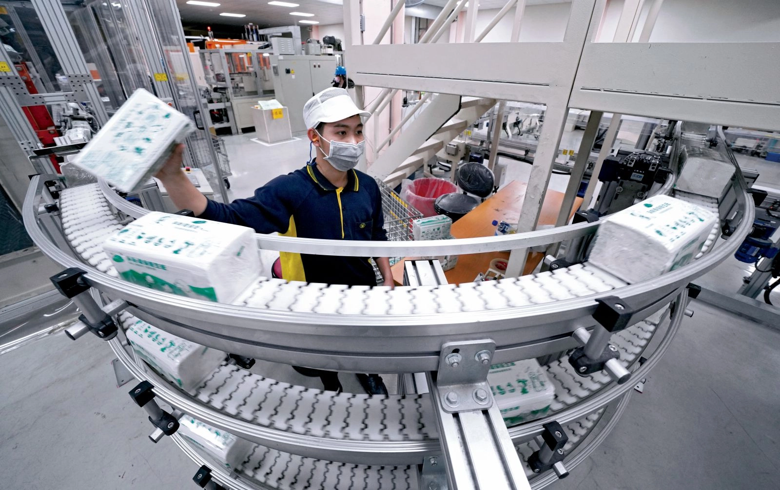 輸送帶上的淨斯環保衛生紙,由回收紙和紙容器下腳料製成,包裝亦採水墨印刷,無毒無味可自然分解。