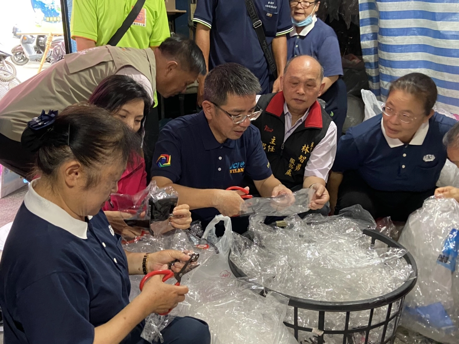 宜蘭市長江聰淵特地前往表揚,並親身體驗剪塑膠袋的工作。(慈濟基金會)