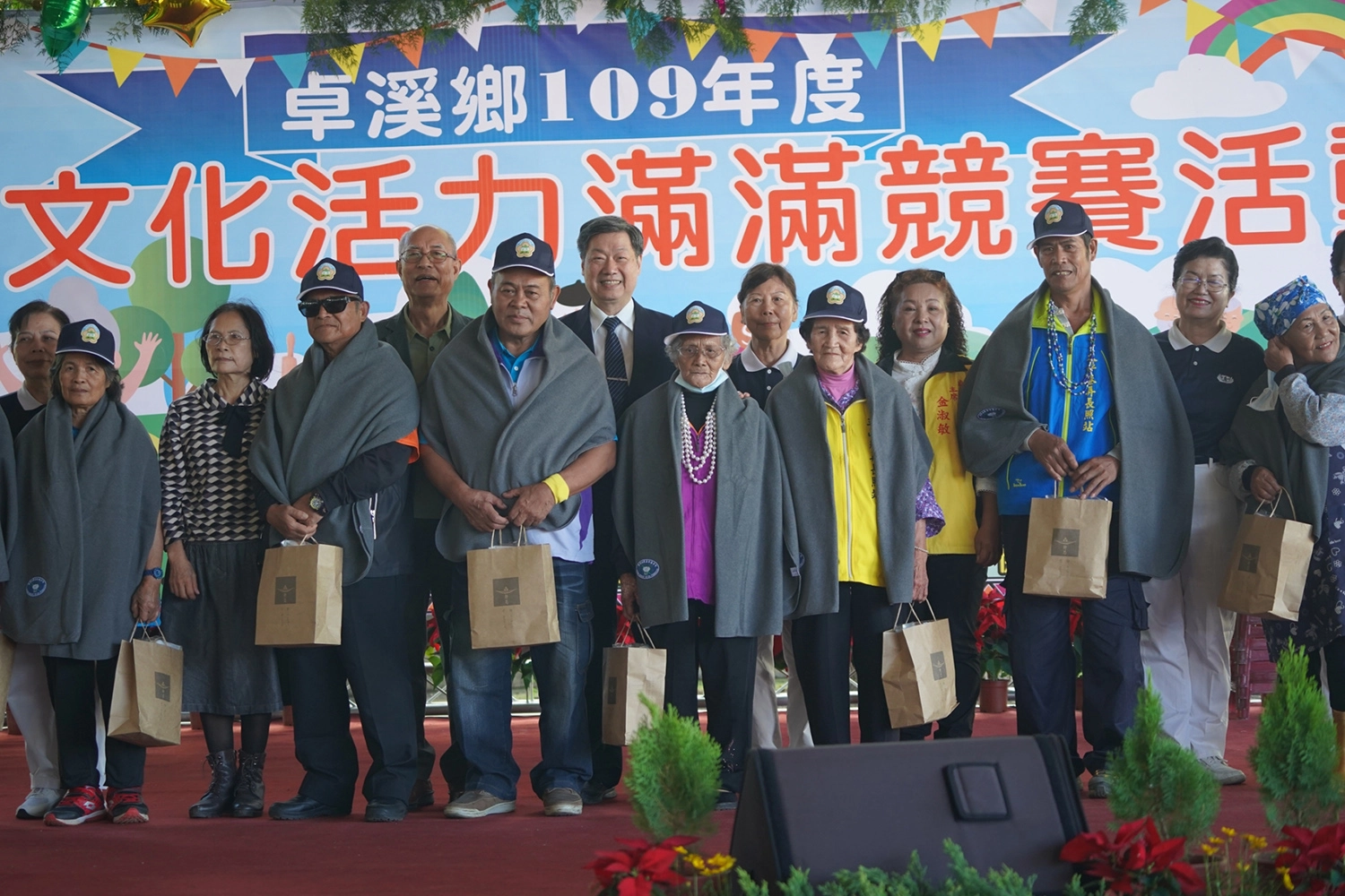 玉里慈濟志工為卓溪鄉長者披上披肩,祝福長者身體健康。 攝影:王嘉彬