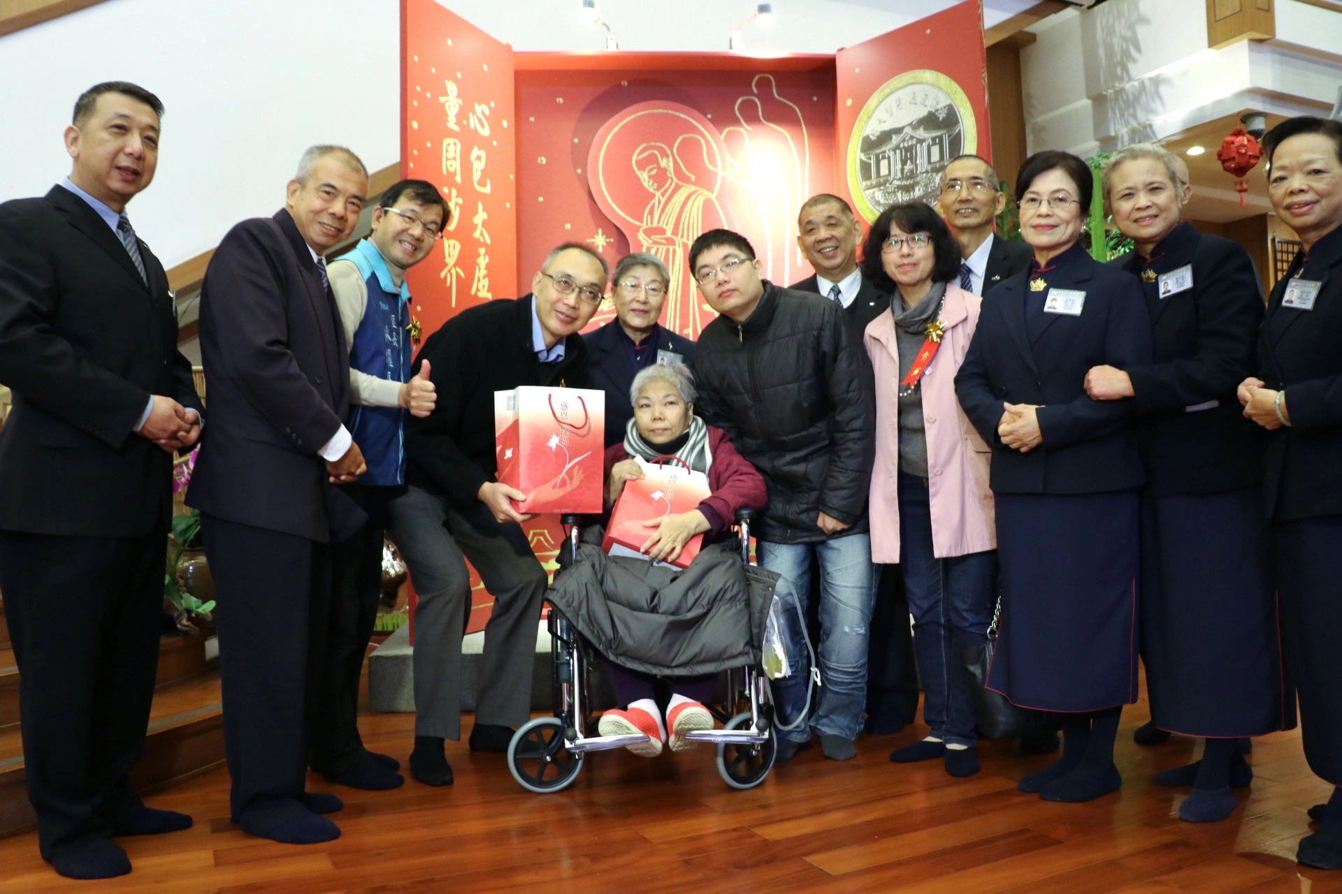謝政達(左4)和慈濟師兄陳成立(左2)代表致贈福袋和物資卡給關懷戶。