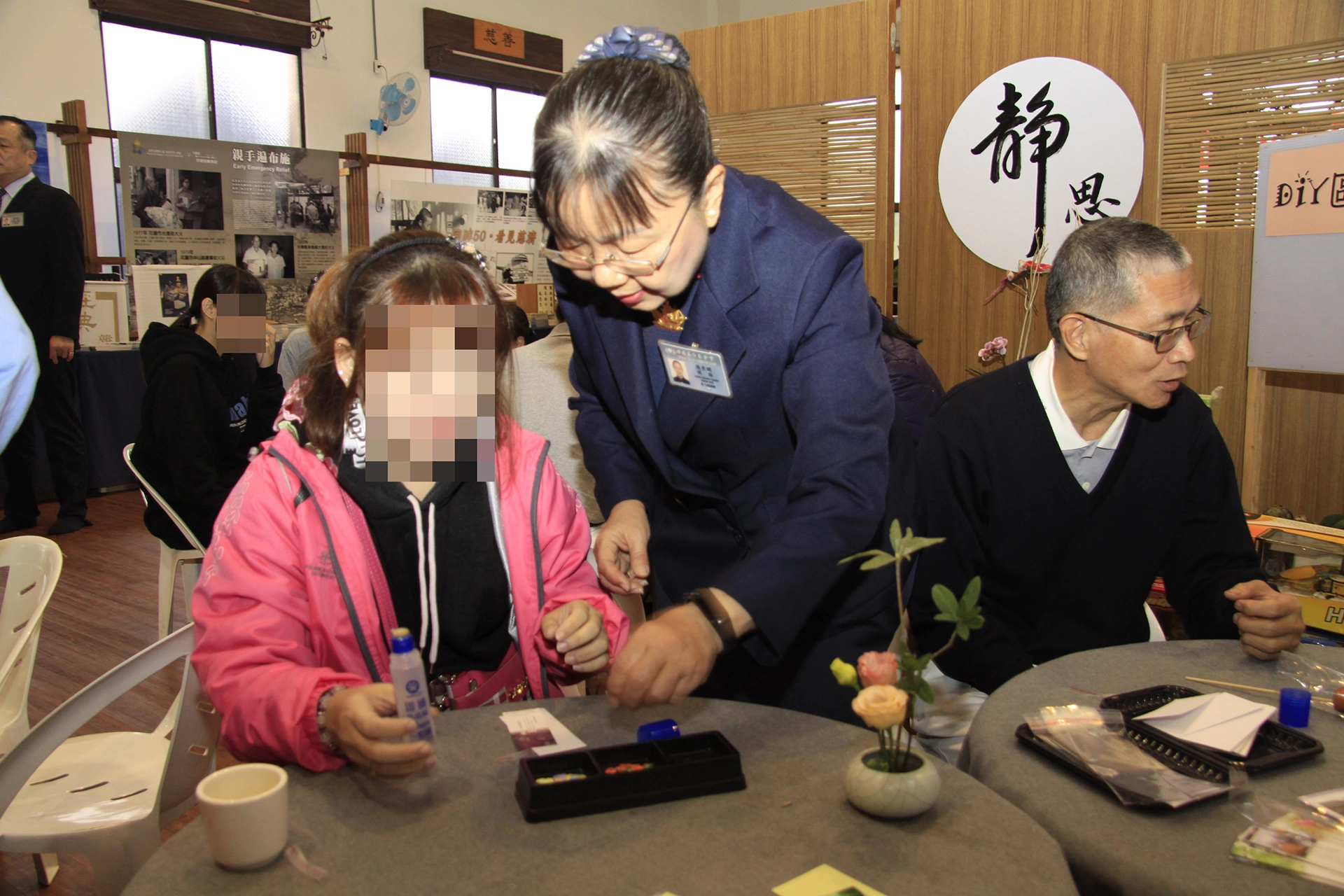 主責志工陳秀嫻陪伴張振華的女兒體驗DIY手做書籤,這也是女兒的興趣之一。