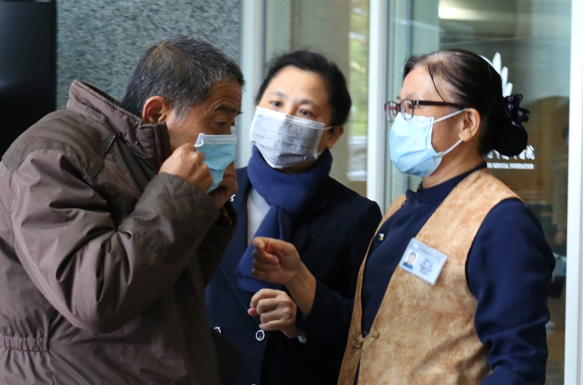 臺中慈濟醫院副院長莊淑婷(中)提醒訪客正確戴口罩。