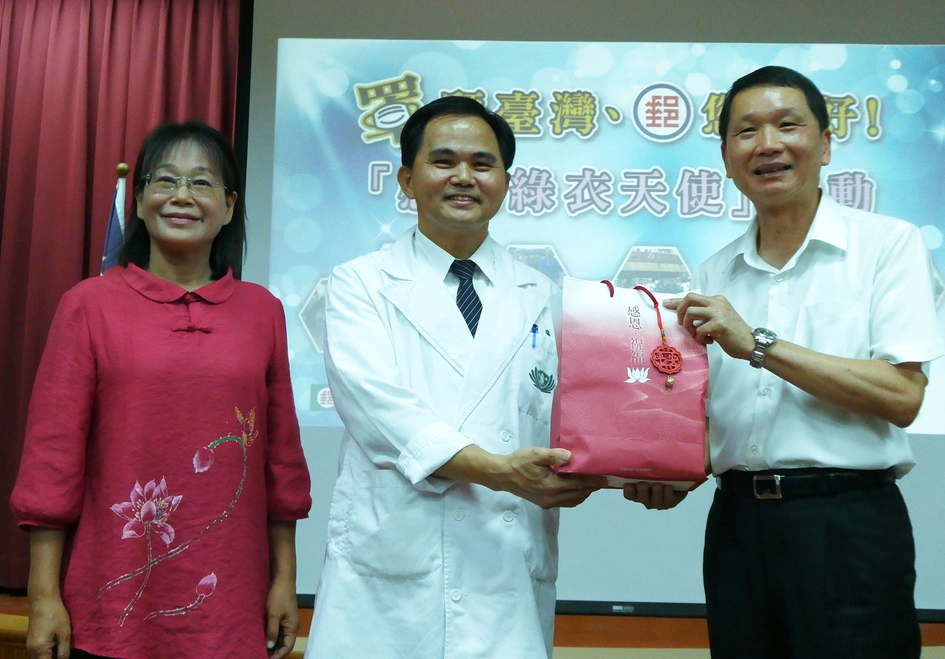 慈濟由斗六慈濟醫院簡瑞騰院長(中)獻上祝福禮給雲林郵局局長吳順吉(右),由雲林縣謝淑亞副縣長(左)見證。