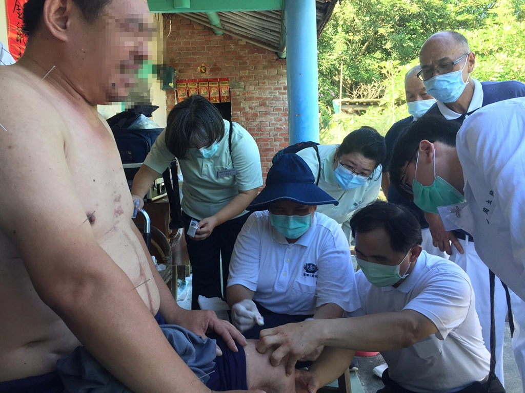 簡瑞騰細心地清理王先生早年車禍在膝蓋留下難癒的傷口,中醫師協助以針灸活絡神經避免肌肉萎縮。