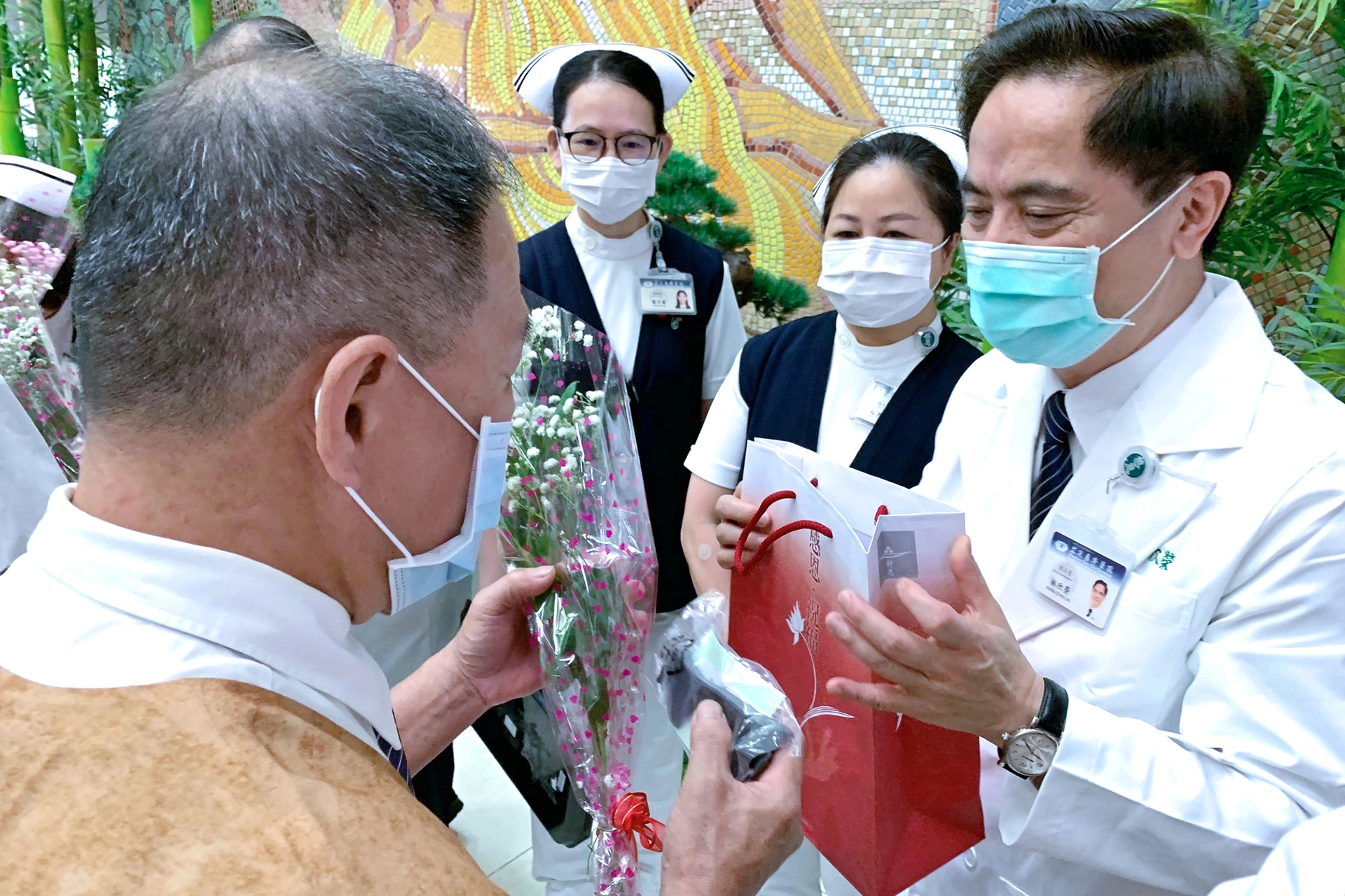花蓮慈濟醫院院長林欣榮帶領團隊,致贈大愛防疫套鏡護目罩組以及充滿愛的玫瑰花,歡迎醫療志工再度「回家」服務。