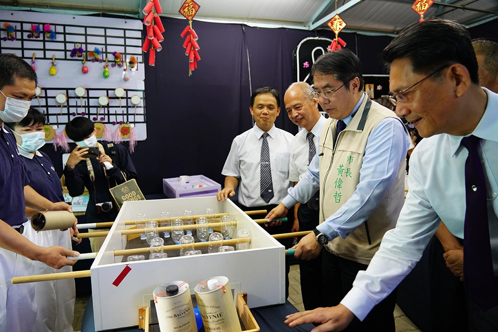 黃偉哲市長參加慈濟綠能館,體驗用回收物製成的遊戲。