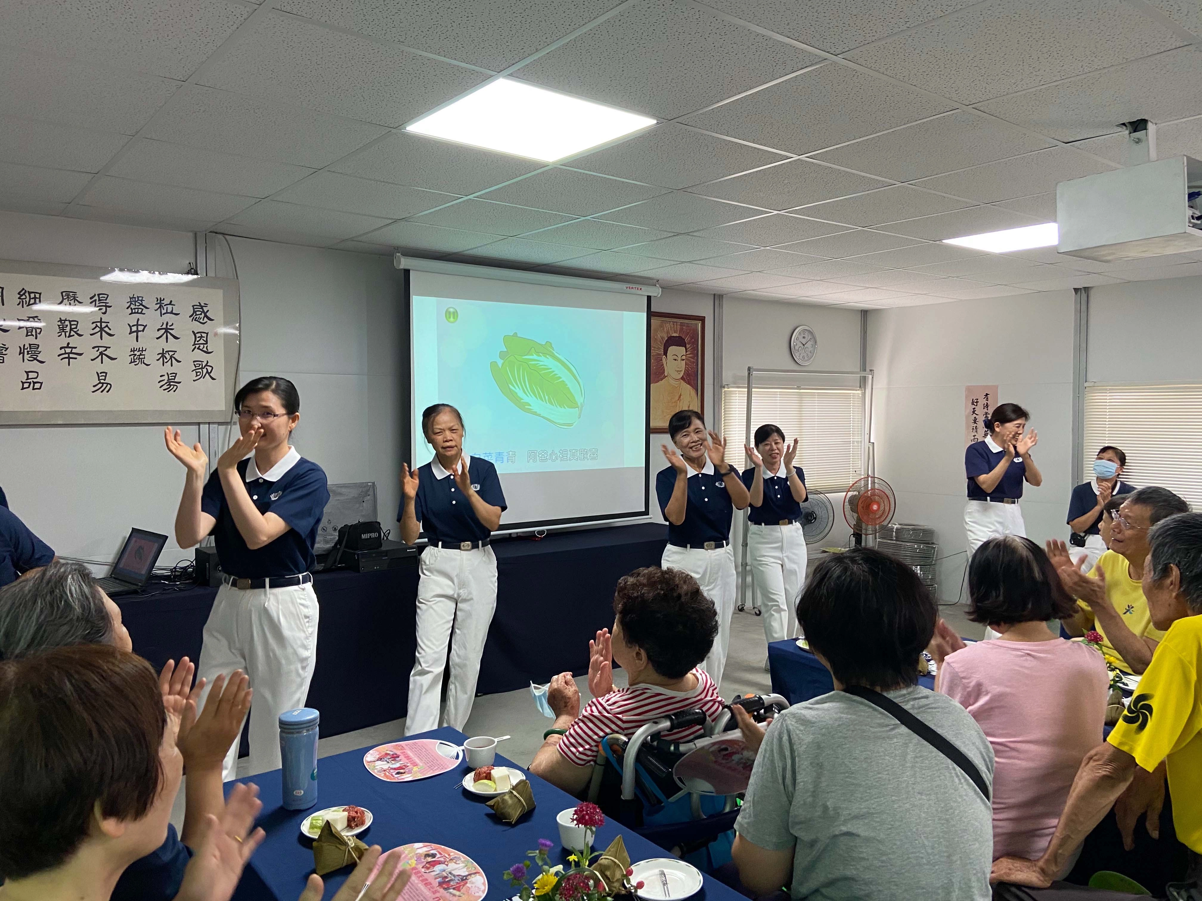 慈濟志工們用手語表演炒熱氣氛,大家跟著老師一起律動,年長者也試著在位子上活動筋骨。
