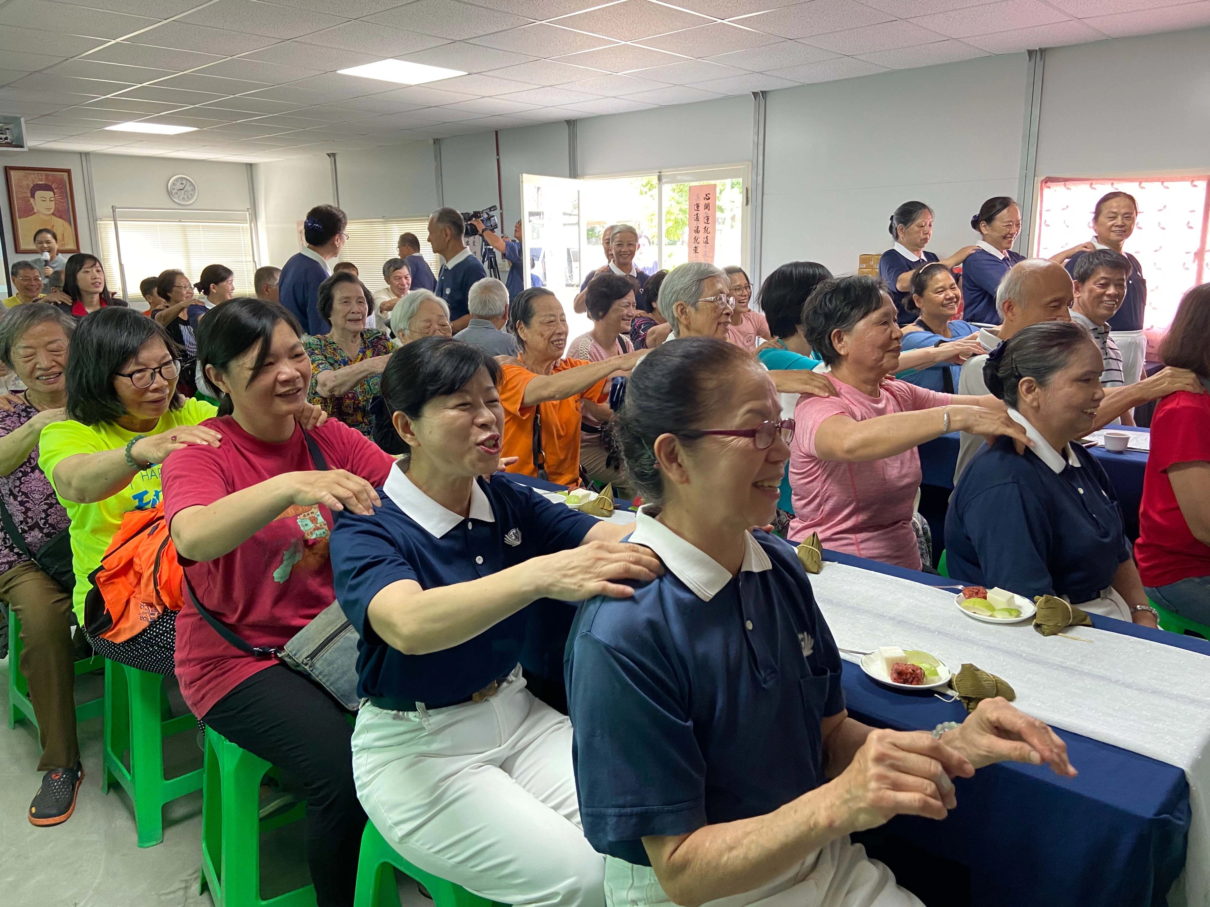 慈濟志工們用手語表演炒熱氣氛,大家跟著老師一起律動,年長者也試著在位子上活動筋骨。