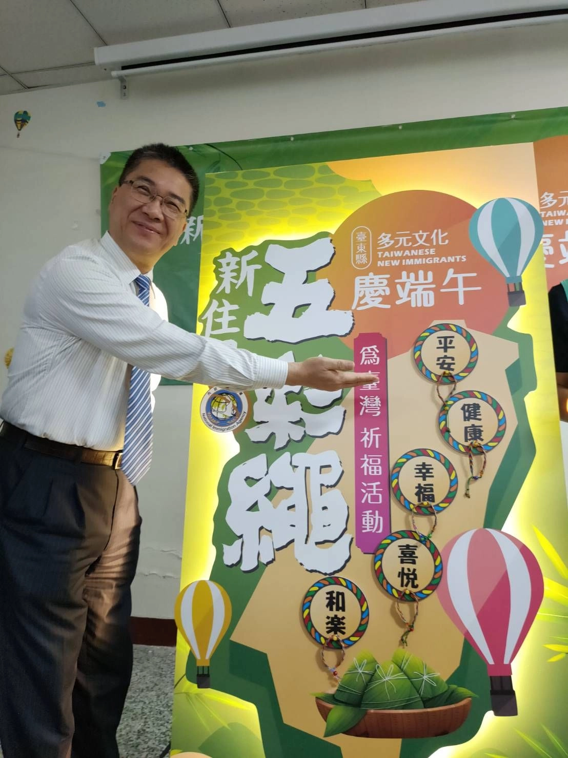 徐國勇和新住民朋友共同將親手製作的五彩繩繫在臺灣圖像看板上,祈求臺灣永保安康!
