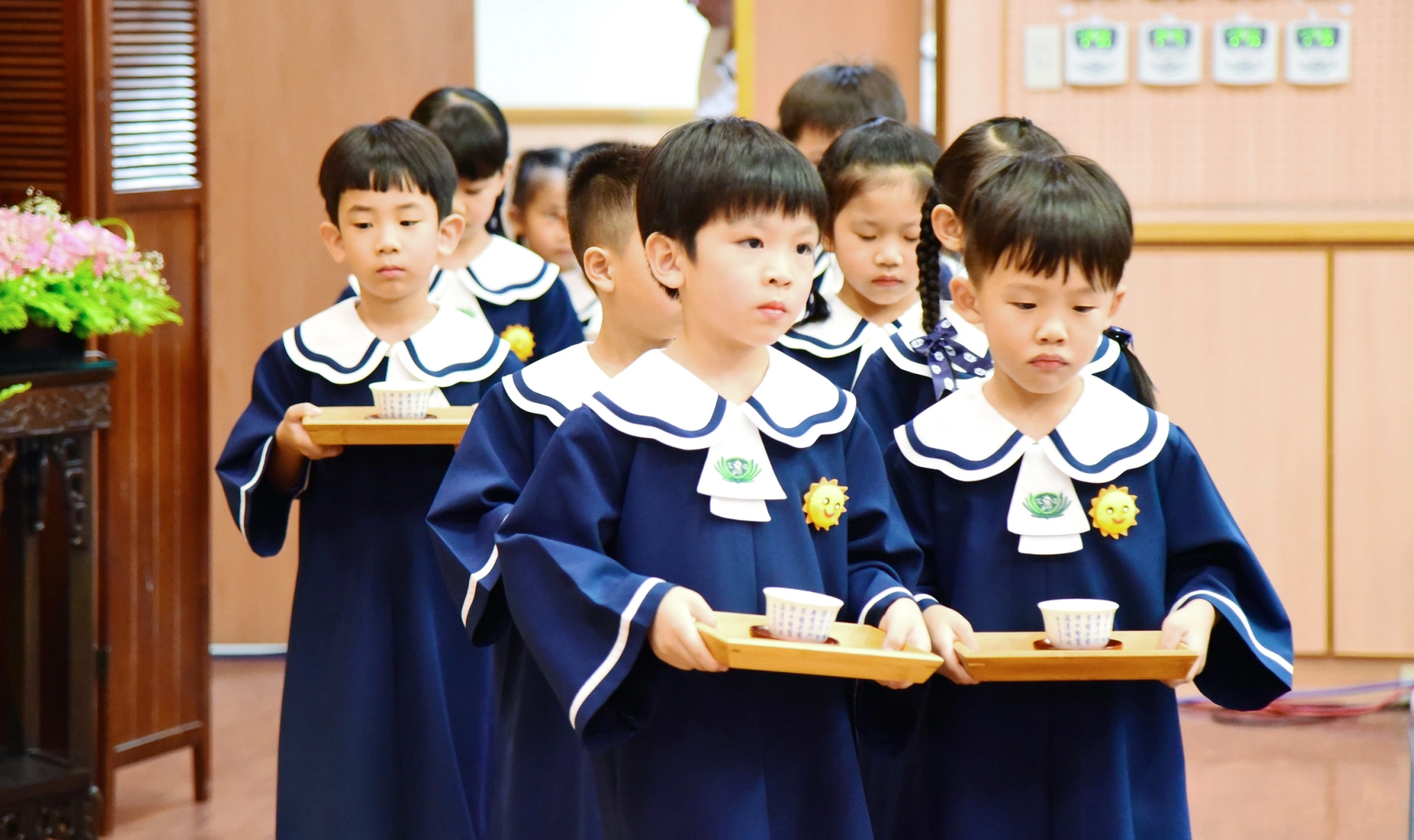 2位畢業生小心翼翼地捧著感恩茶,獻給一路無私奉獻、不辭辛勞的家長和師長。