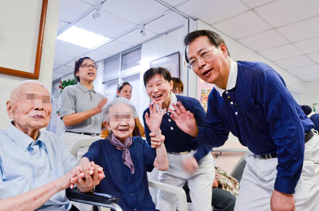 臺北慈濟醫院醫護行政同仁與慈濟志工至北區老人之家關懷長者。圖:副院長張耀仁(右)與長者歡喜互動。