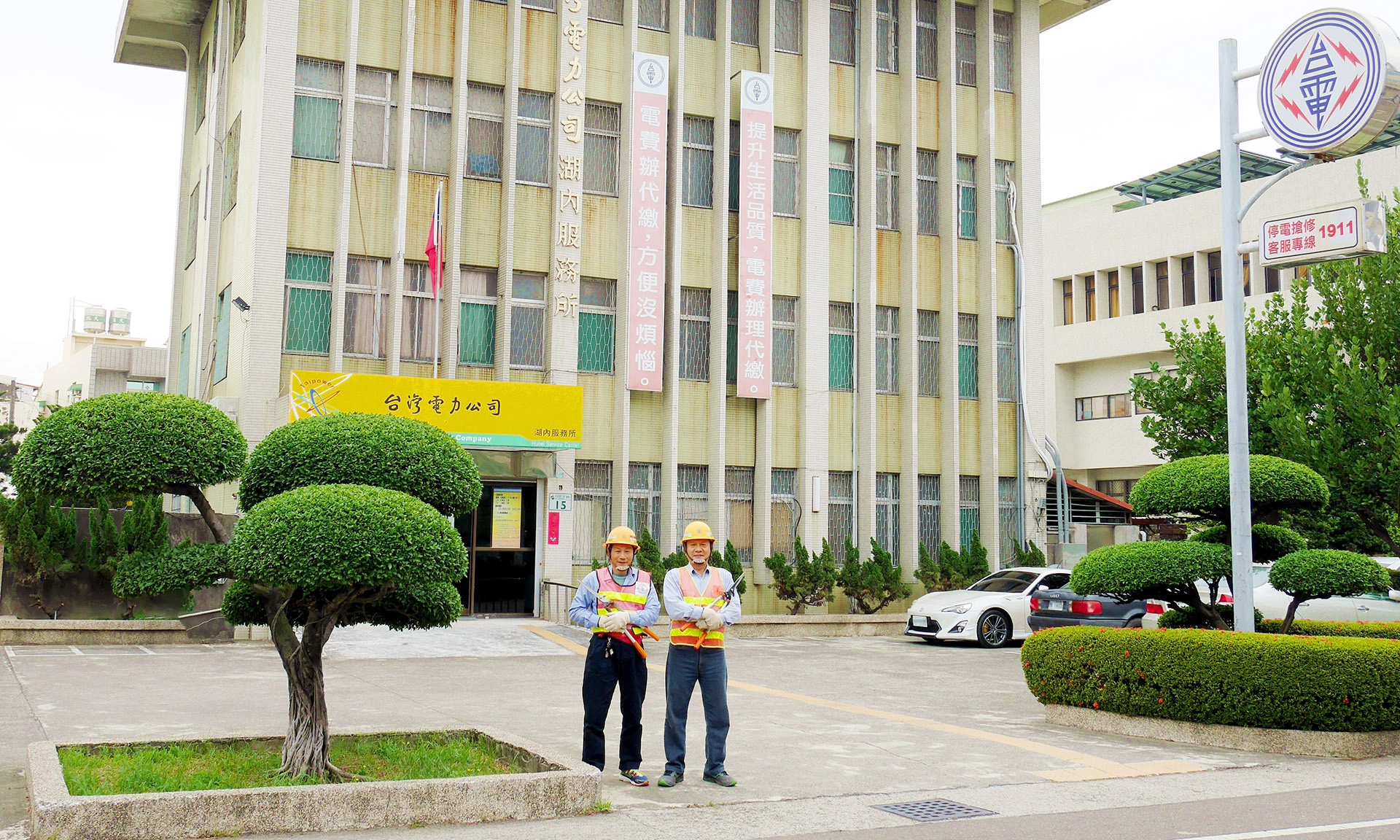 台電高雄湖內服務所資深員工葉華嘉(右)和王萬益(左),利用假日回到所內整理樹木,門口饅頭造型樹雕成為當地民眾熱議話題,甚至用google街景也能看到。