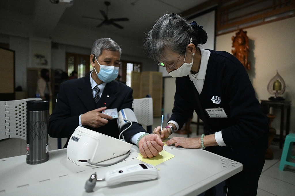 當年和平醫院檢驗技術員張敏如,如今是「專職」慈濟志工,在社區或環保站幫人量血壓,邊聊慈濟,給人紓壓。