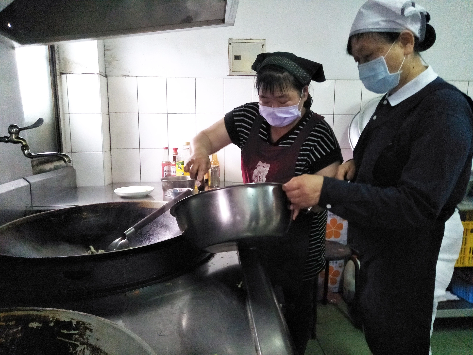 公司負責中餐烹調的曾麗珍小姐(左),感恩老闆推動素食,他說煮蔬食比較沒有油煙。