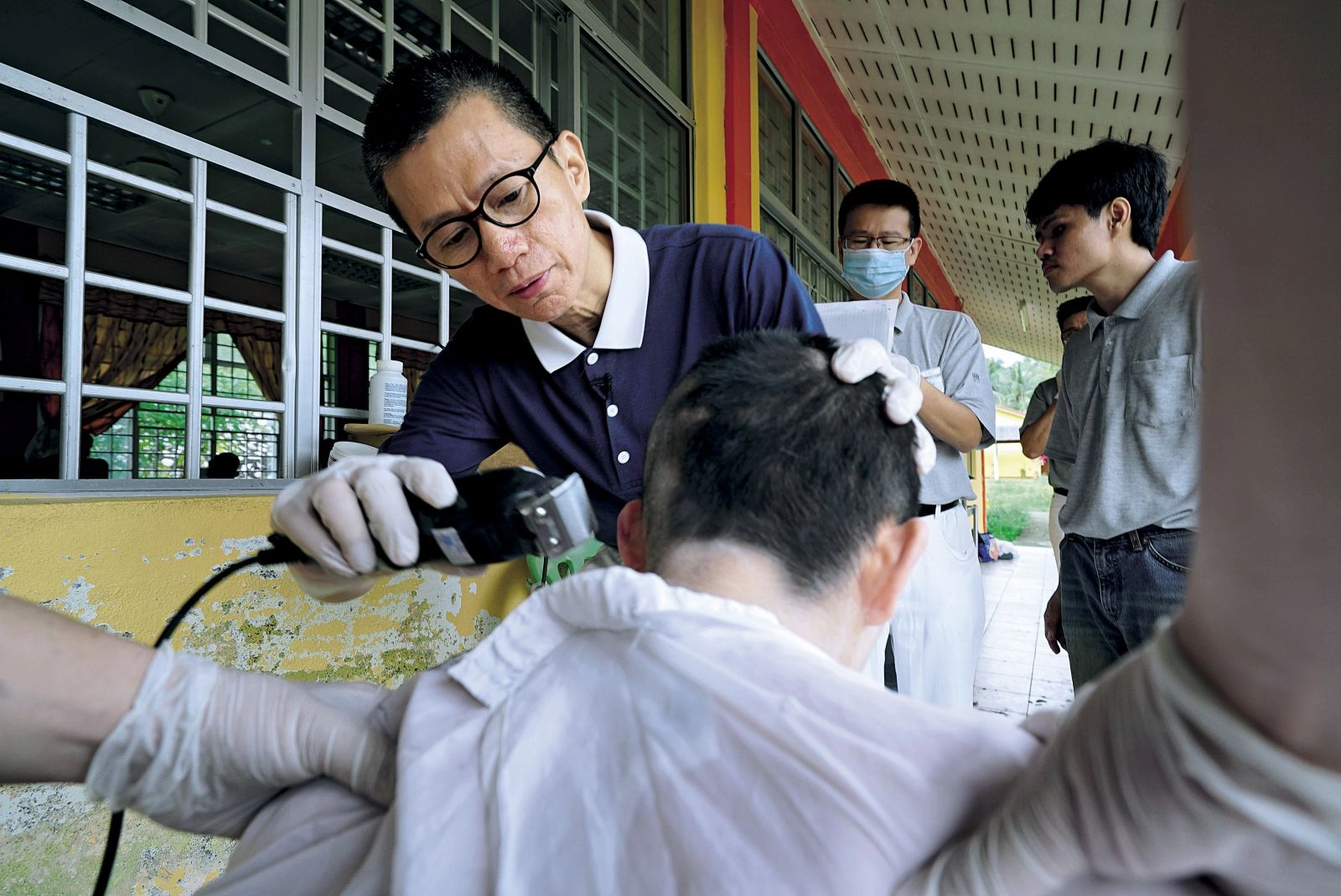 林孝式在殘智障院為院友理髮;他曾經拿健康換取金錢,如今難捨能捨,成為更多人生命中的貴人。(攝影/蕭耀華)