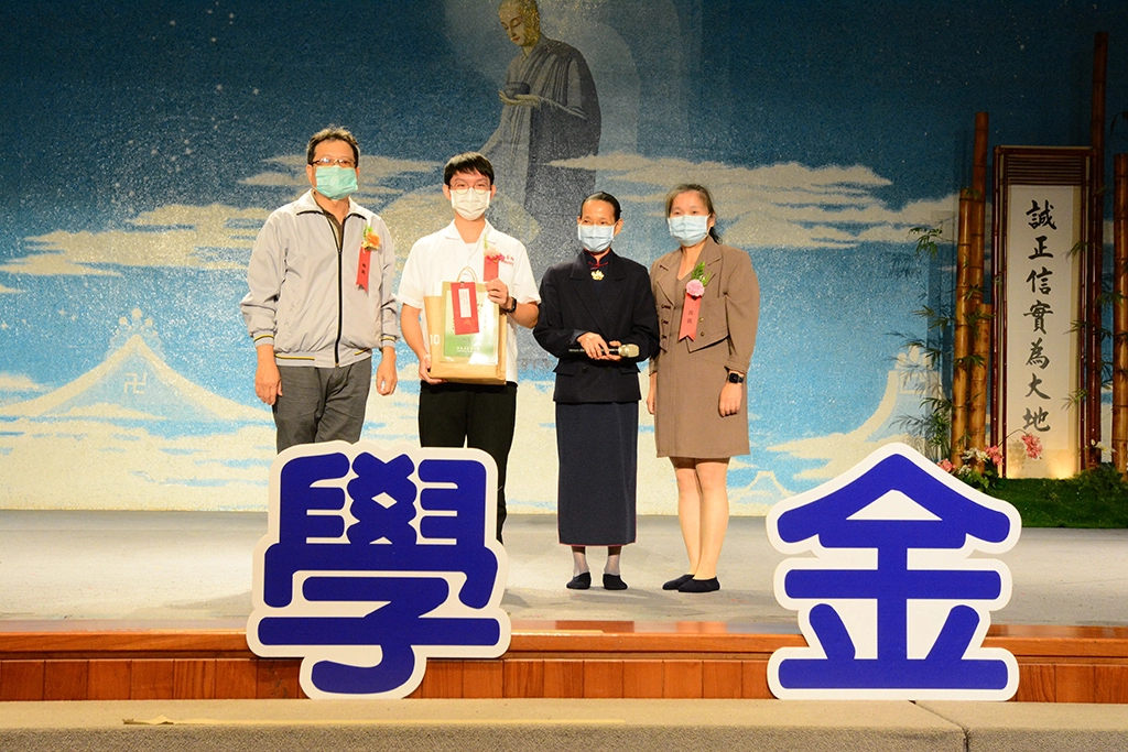 台南高商進修部李正智主任(左)、導師武麗英(右)及陪伴志工出席頒獎典禮,將獎狀頒發給葉俊億(左二)。