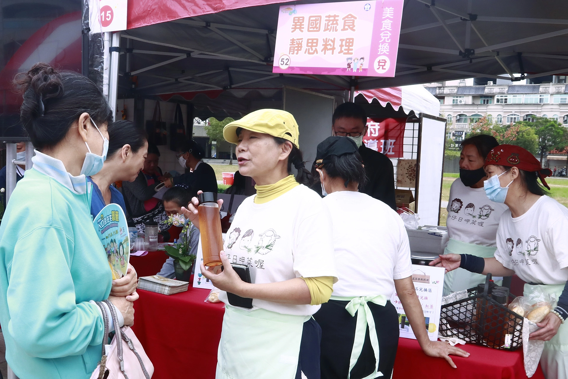 異國蔬食靜思料理攤位上,志工嚴玉女忙著跟民眾介紹推廣蔬食料理。