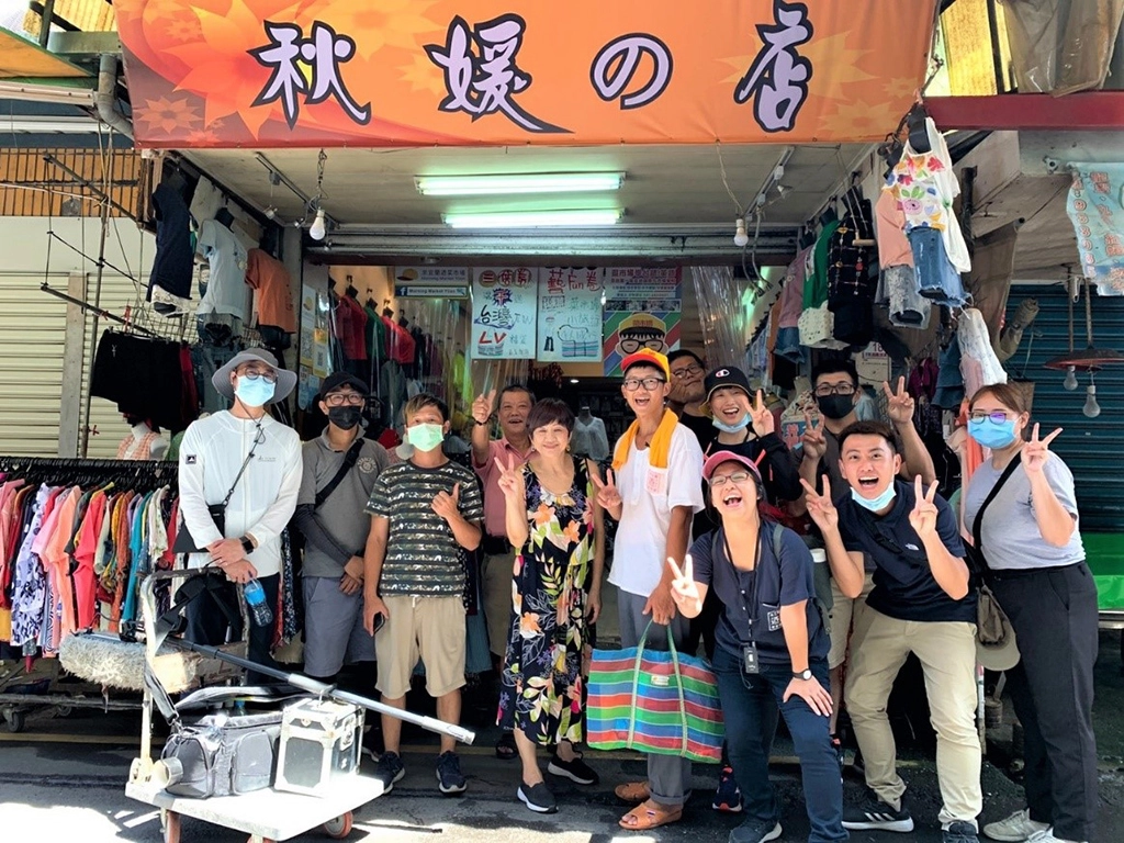 青年開心於宜蘭菜市場中經營超過40年、同時也是團隊成員方子維的家「秋媛的店」合影,透過市場導覽的過程中,認識宜蘭在地故事。