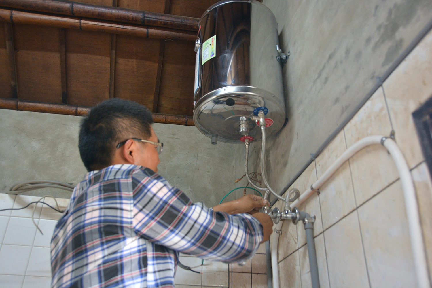 慈濟協助將劉先生的廚房換上全新的電熱水器,取代怕漏煤氣的燃煤的熱水器。