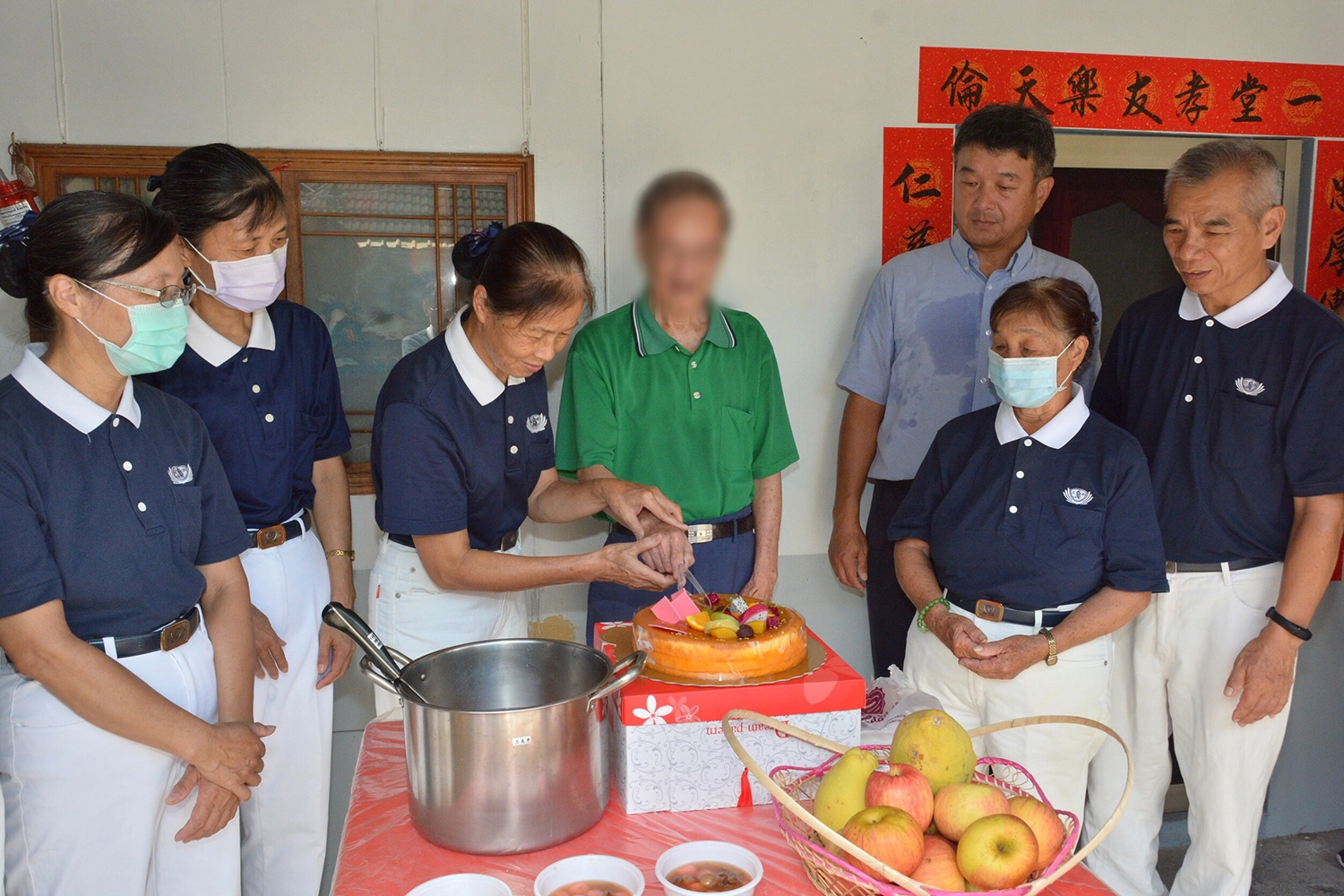 志工陳惠卿代表與劉先生一起切蛋糕,慶祝新居圓滿。