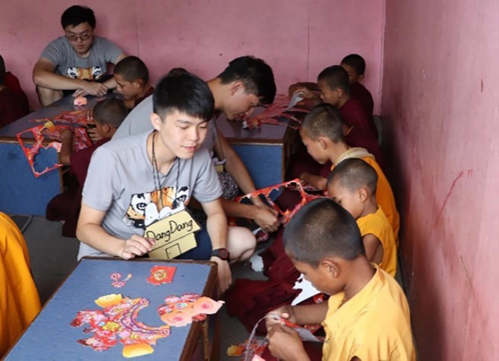 國防醫學院享尼尼泊爾國際志工團團員在佛學院進行元宵節慶課程,教導孩童製作燈籠。