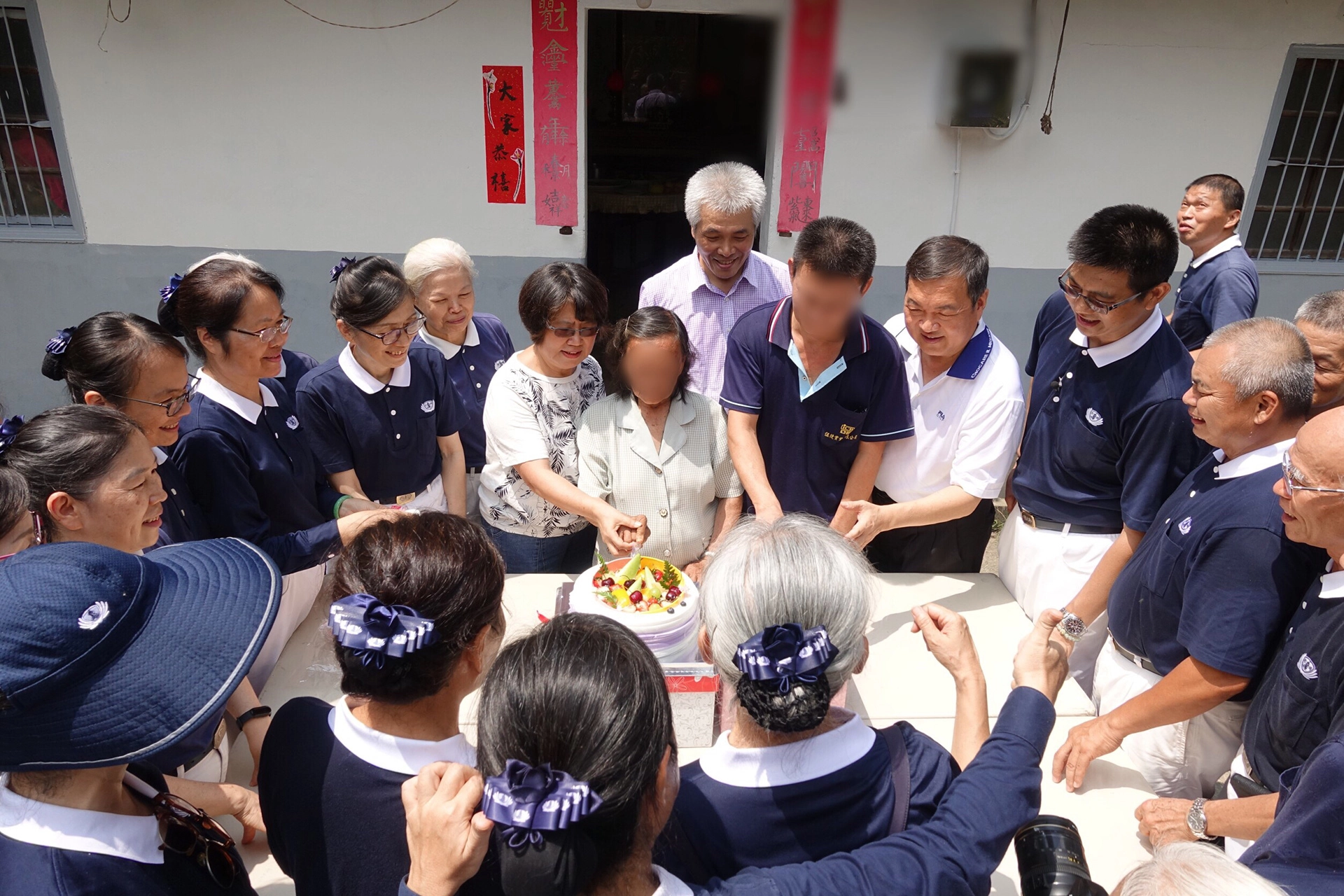 志工與鄰近居民一起來慶祝阿嬤入厝。