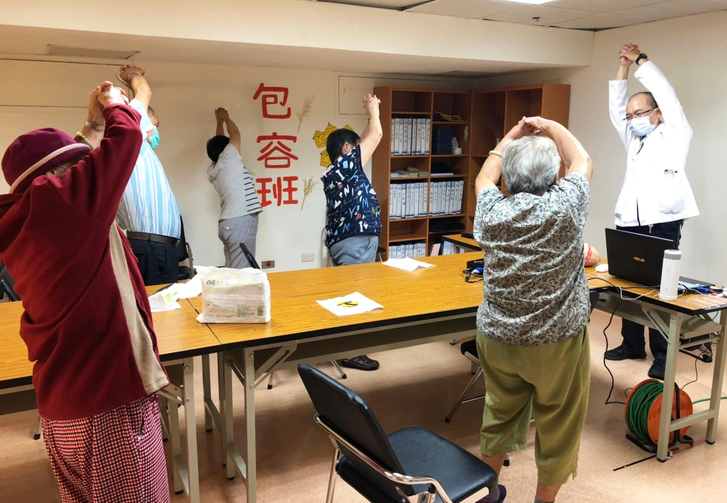 物理治療師林啟文示範帶動頭、上肢、手臂伸展動作,訓練長輩肌肉伸展。
