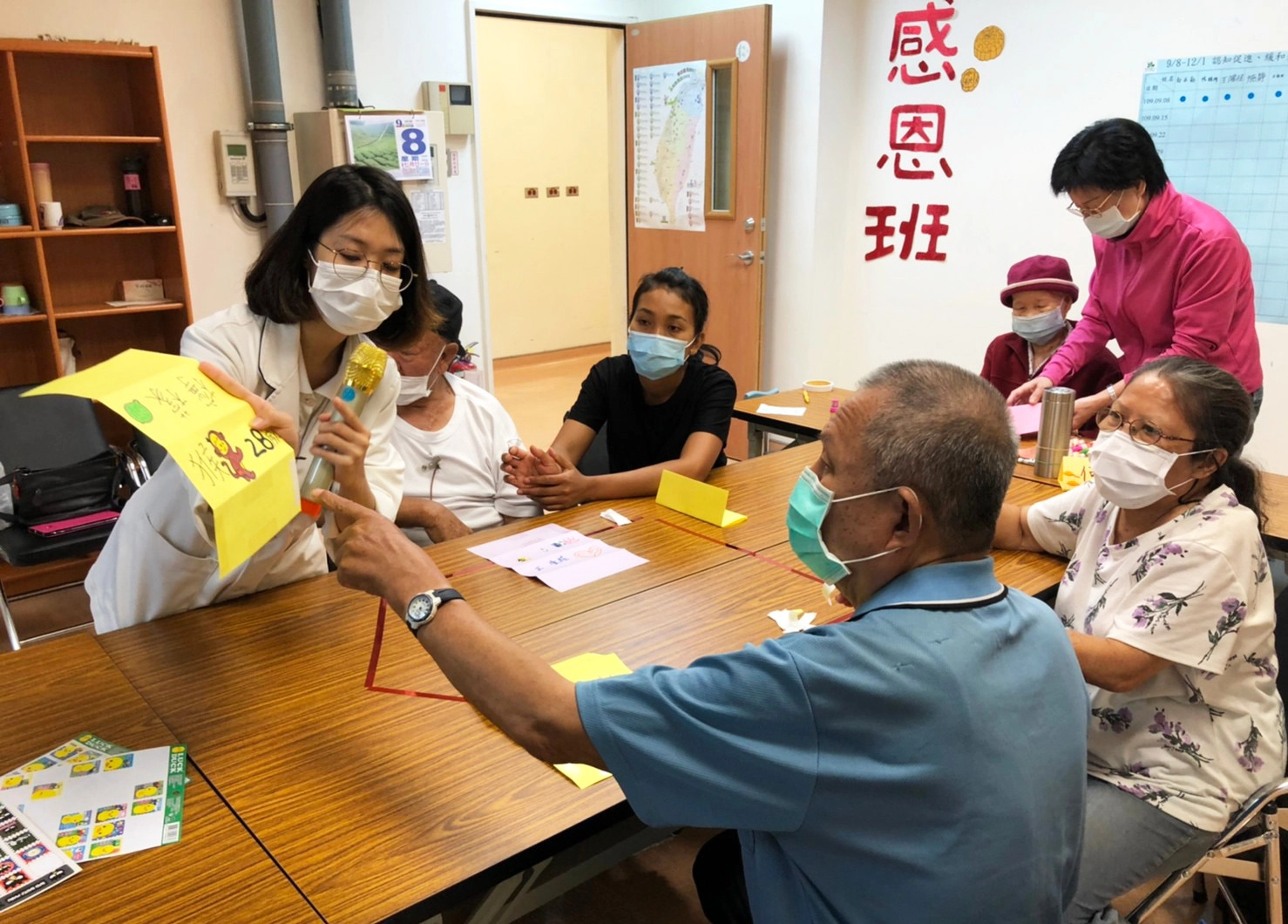 職能治療師林易萱指導學員製作名牌,運用玩接龍遊戲,讓家屬及長輩做記憶認知保養。