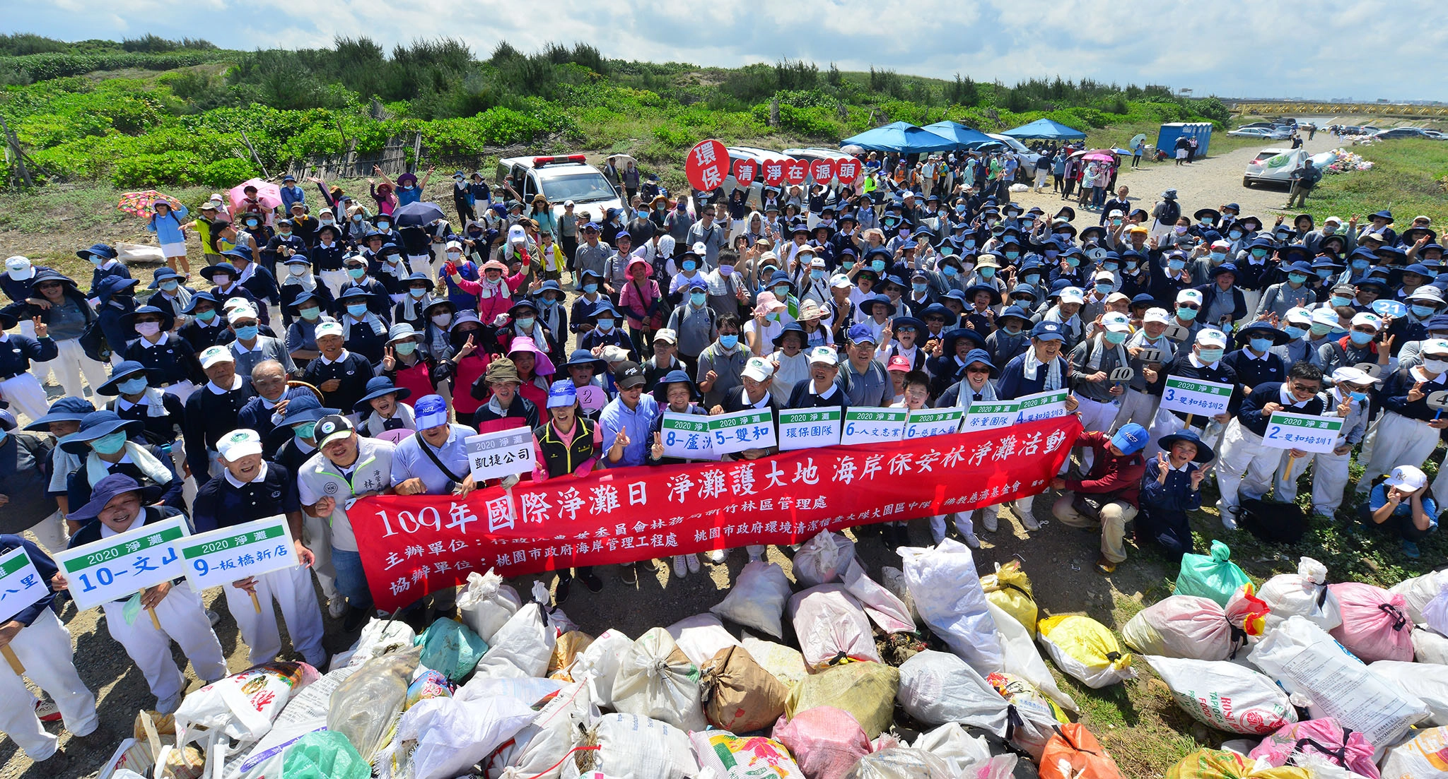 國際淨灘日,全體參與志工與民眾在清出的五千公斤垃圾前,宣示淨灘護大地。
