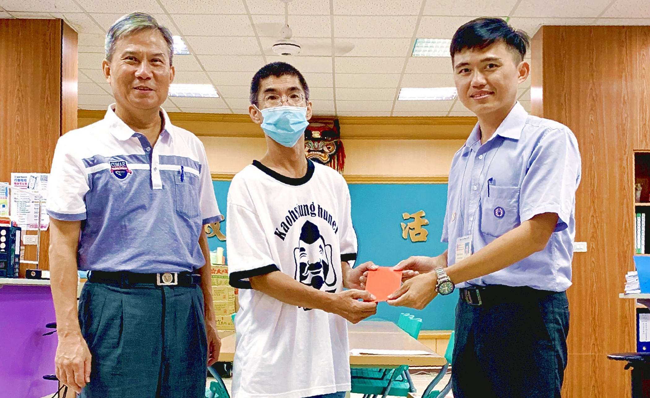 台電高雄區處今(25)日由處長李衍新及同仁分頭走訪多間社福機構及在地弱勢民眾。住在高雄湖內的低收入戶阿傑(化名、正中間)在區長薛茂竹(左)見證下,從台電湖內服務所所長莊誌豪(右)手中接過「幸福準備金」,阿傑神情憔悴卻仍難掩激動,不停向台電同仁致謝。