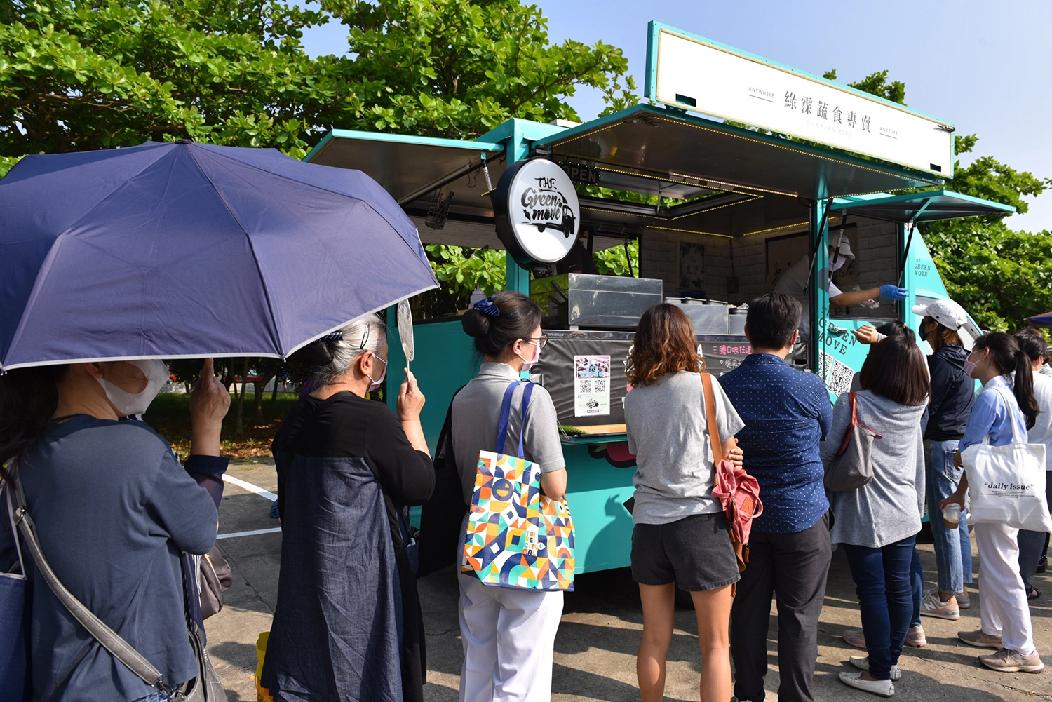 四月的午後豔陽高照,高達31度的高溫,每個攤位仍然井然有序的排著隊伍。(攝影者:蔡宜達)