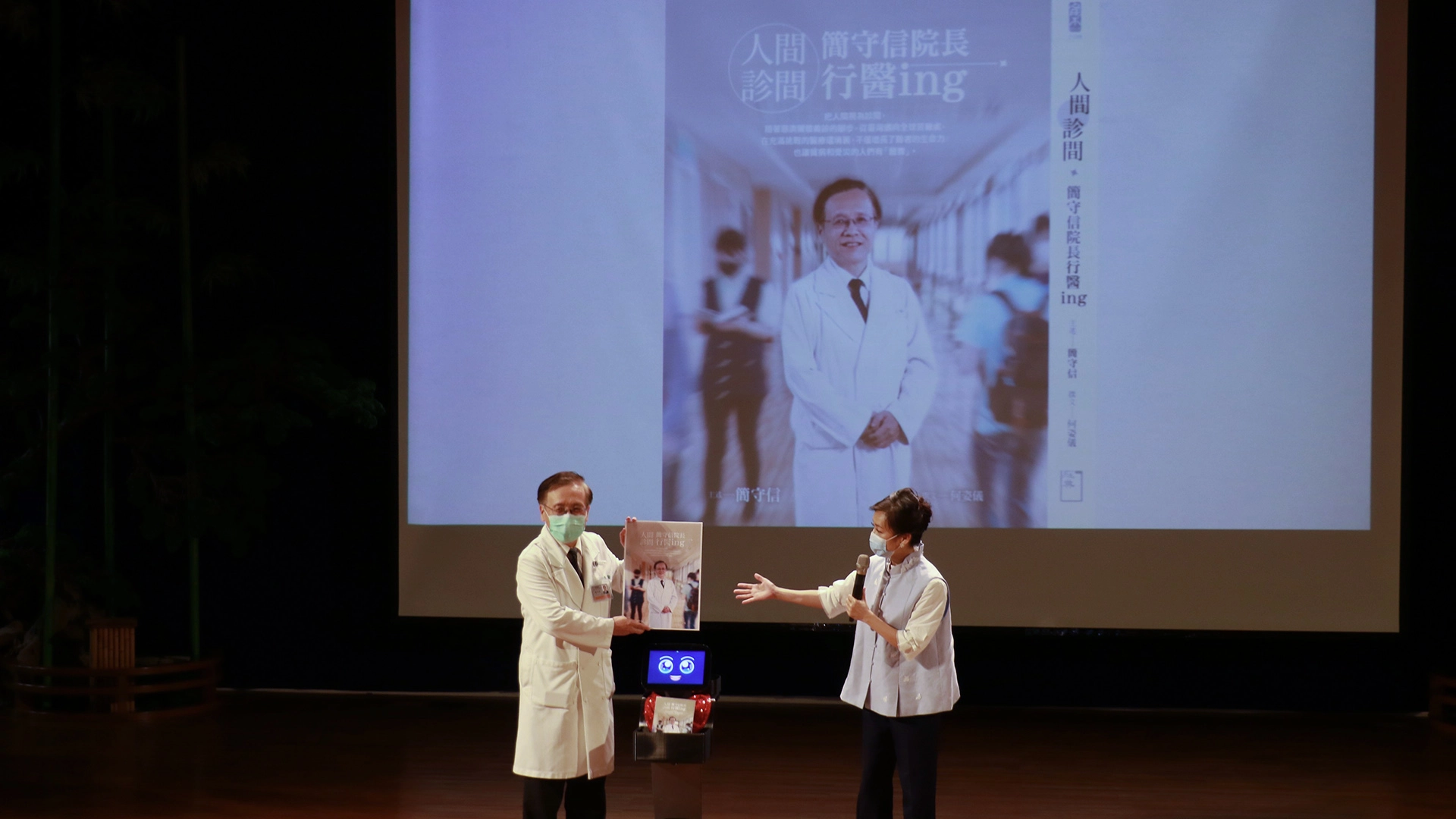 智能機器人送出書本封面,預告簡守信院長將推出新書。