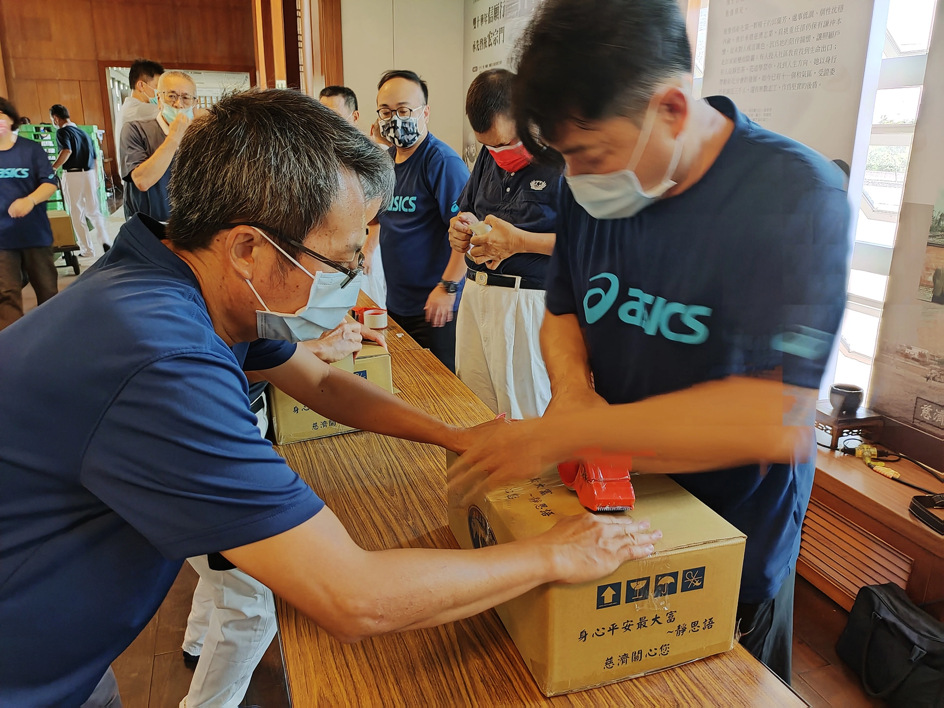 彰化縣教育處卓鴻賓課督(左)與慈濟志工一起打包第二批暑期安心生活箱,過程中感到很歡喜。