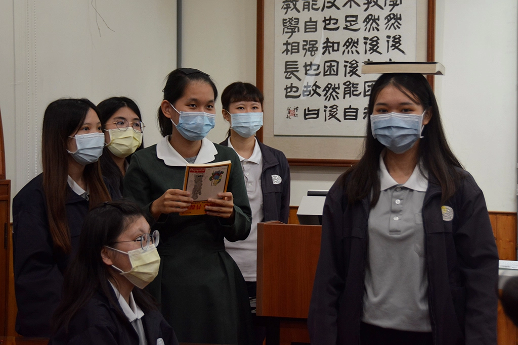 學生頭頂書本,練習直線走路,才知道抬頭挺胸,姿勢端正有多重要。