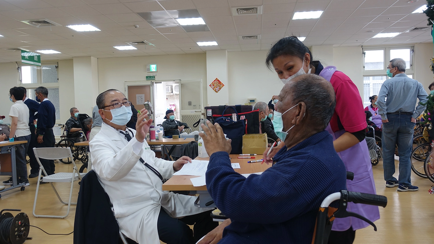 東區慈濟人醫會12月11日到台東仁愛之家義診,許文林副院長主動向住民打招呼,陳爺爺(右)讚嘆慈濟醫護人員「NO.1」「Very good!」(攝影:陳誼謙)