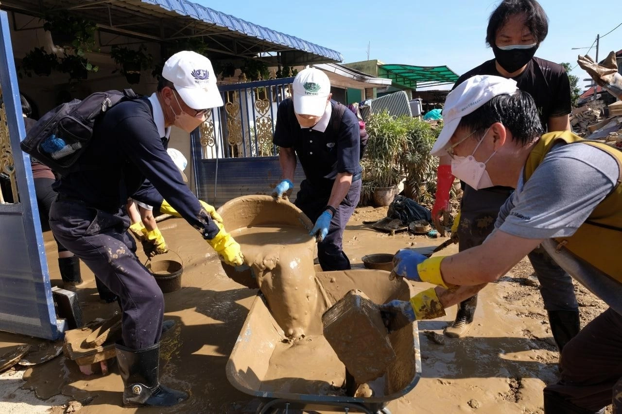 馬來西亞遭逢水患,慈濟志工號召民眾一起投入清掃工作。(圖為慈濟基金會提供)