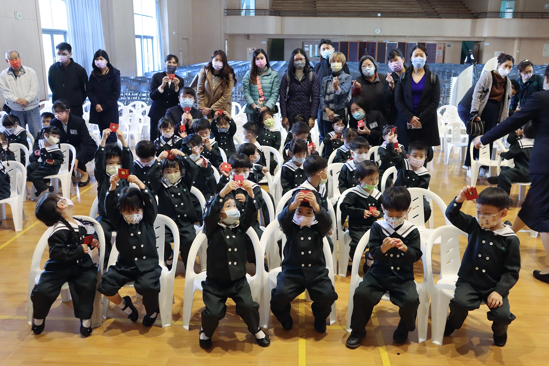 第一次和爸爸媽媽一起在學校參與歲末祝福,幼兒園的孩子開心地展示手中的福慧紅包。