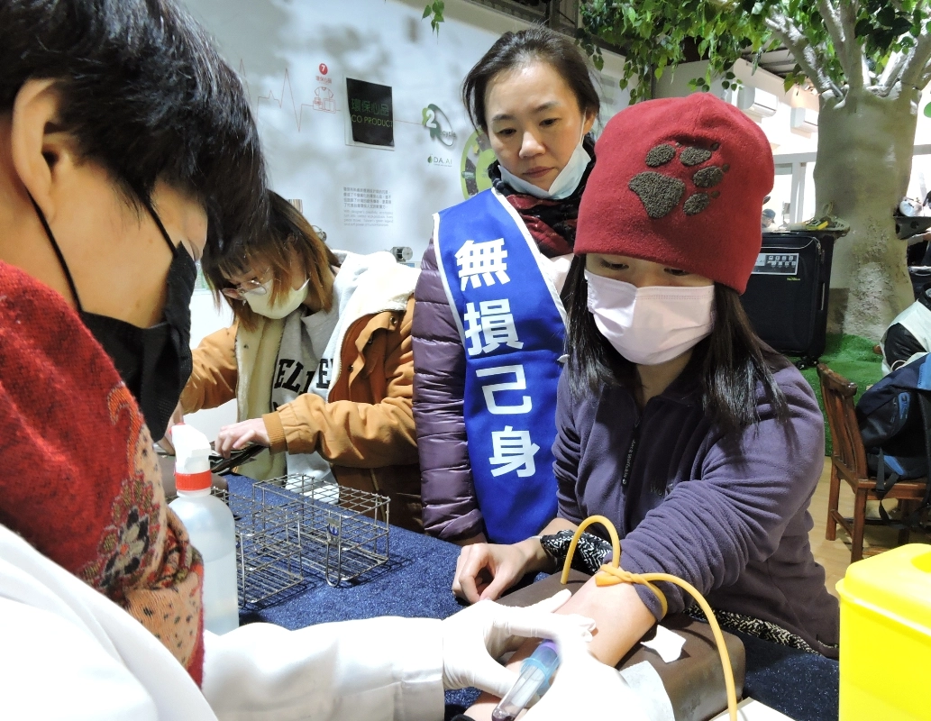 志工許育珮穿上「捐髓救人、無損己身」的背心,親切陪伴前來響應的民眾。