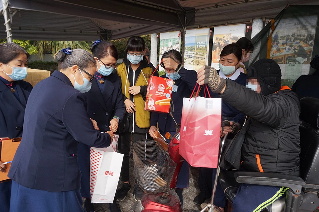 慈濟志工合心協助將歲末物資品整理,讓照顧戶安全載運車上。